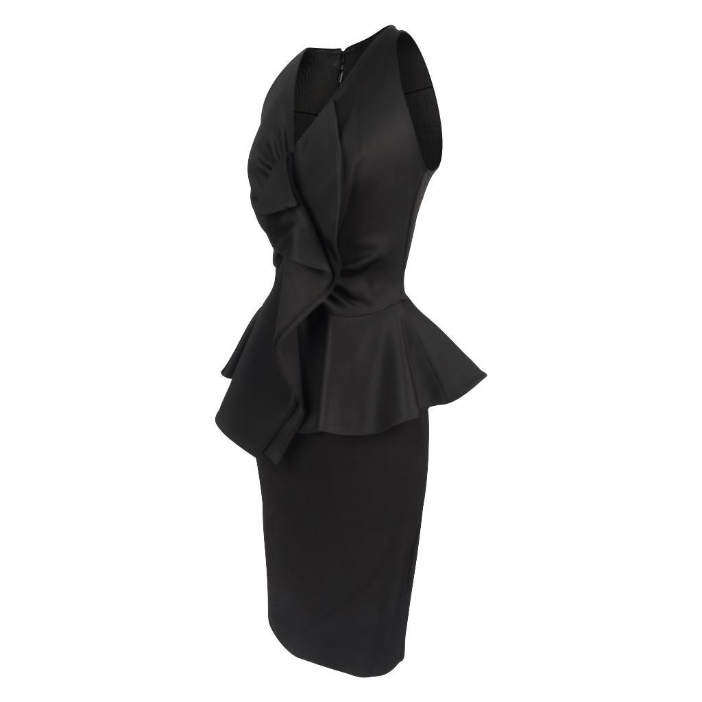 Guaranteed authentic Givenchy striking black fitted dress.
Charming cut away shoulders.
V neck with front ruffle flowing down to peplum waist.
Rear zip with stitch detail near neckline.
Fabric is viscose, polyamide and elastane cotton.
Loose stitch