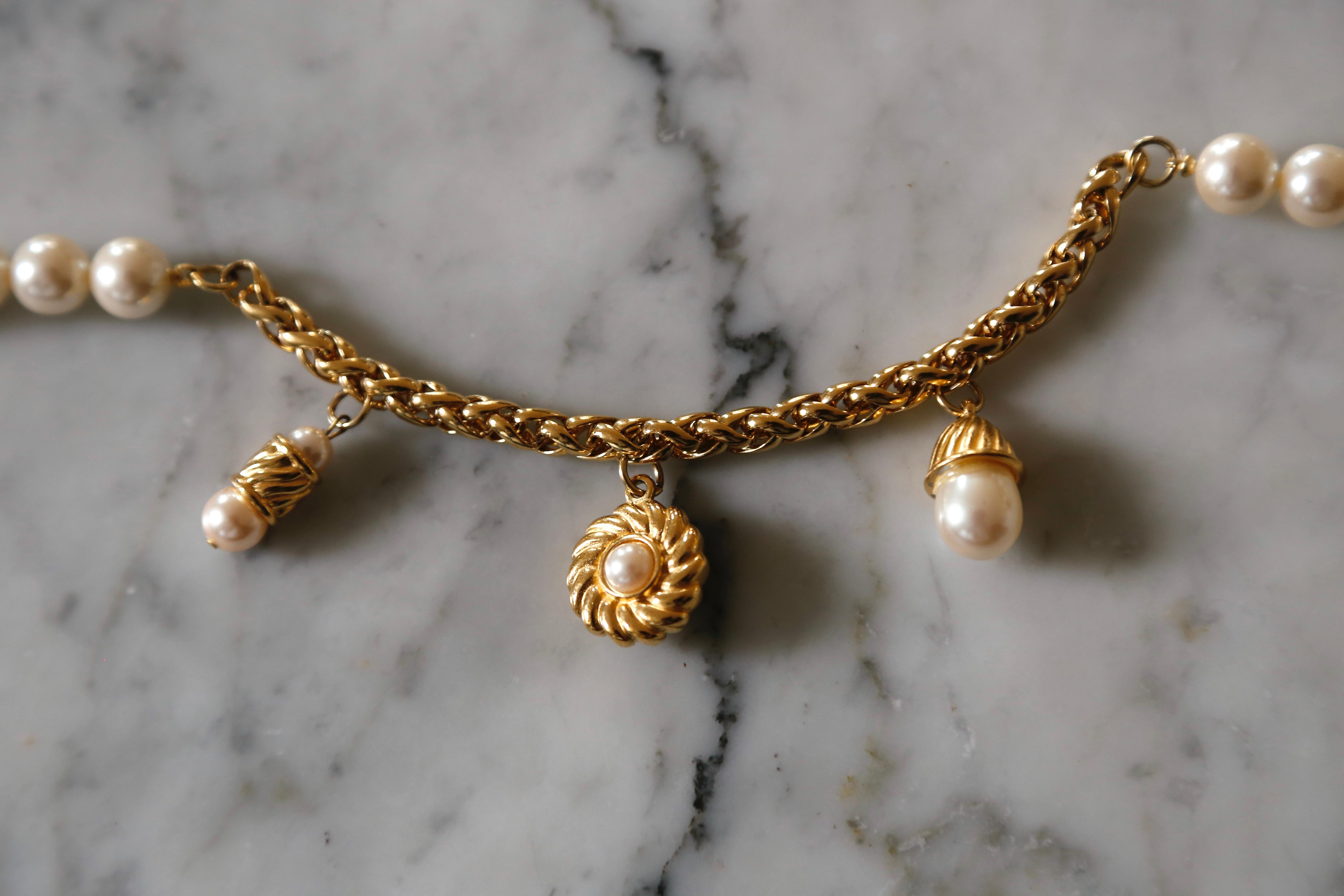 Extra-long, faux-pearl necklace with gilt charm detail at sides from Givenchy dating to the 1980s.  Measures 35