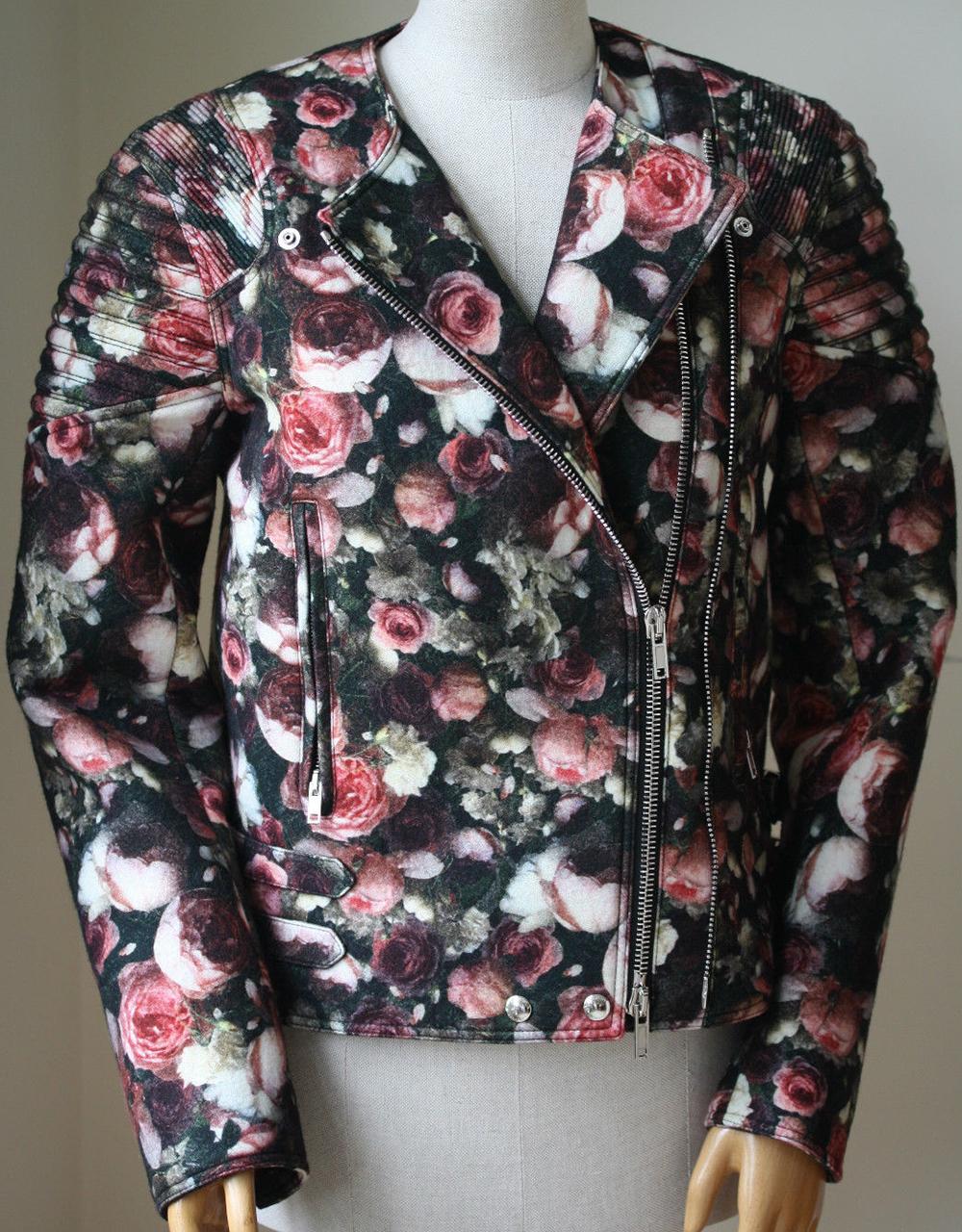 Multi-pink, green and black floral felt wool bomber jacket from Givenchy. Press stud lapels lead into an off-centre zip down front. Structured and ribbed shoulder pads. Long sleeves with exposed and elongated zip cuffs. Two front zip pockets. Double