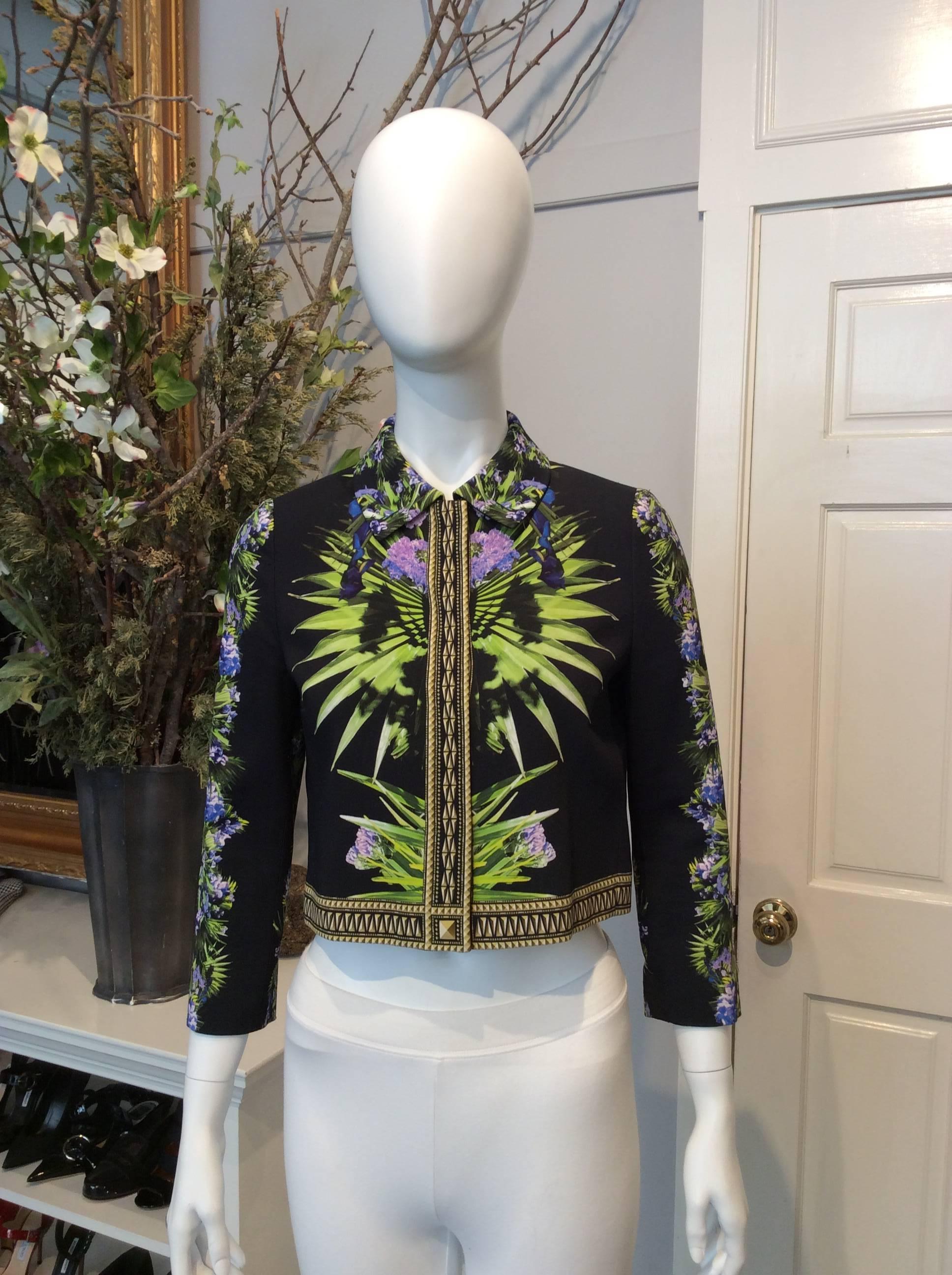 Givenchy black cropped jacket with purple and green floral pattern throughout, including length of sleeves. Yellow and gold trim. Concealed button closures down front of jacket. 

Sizing: Fr36, Us4

Fabric content: 96% Viscose, 4% Elastane. Body