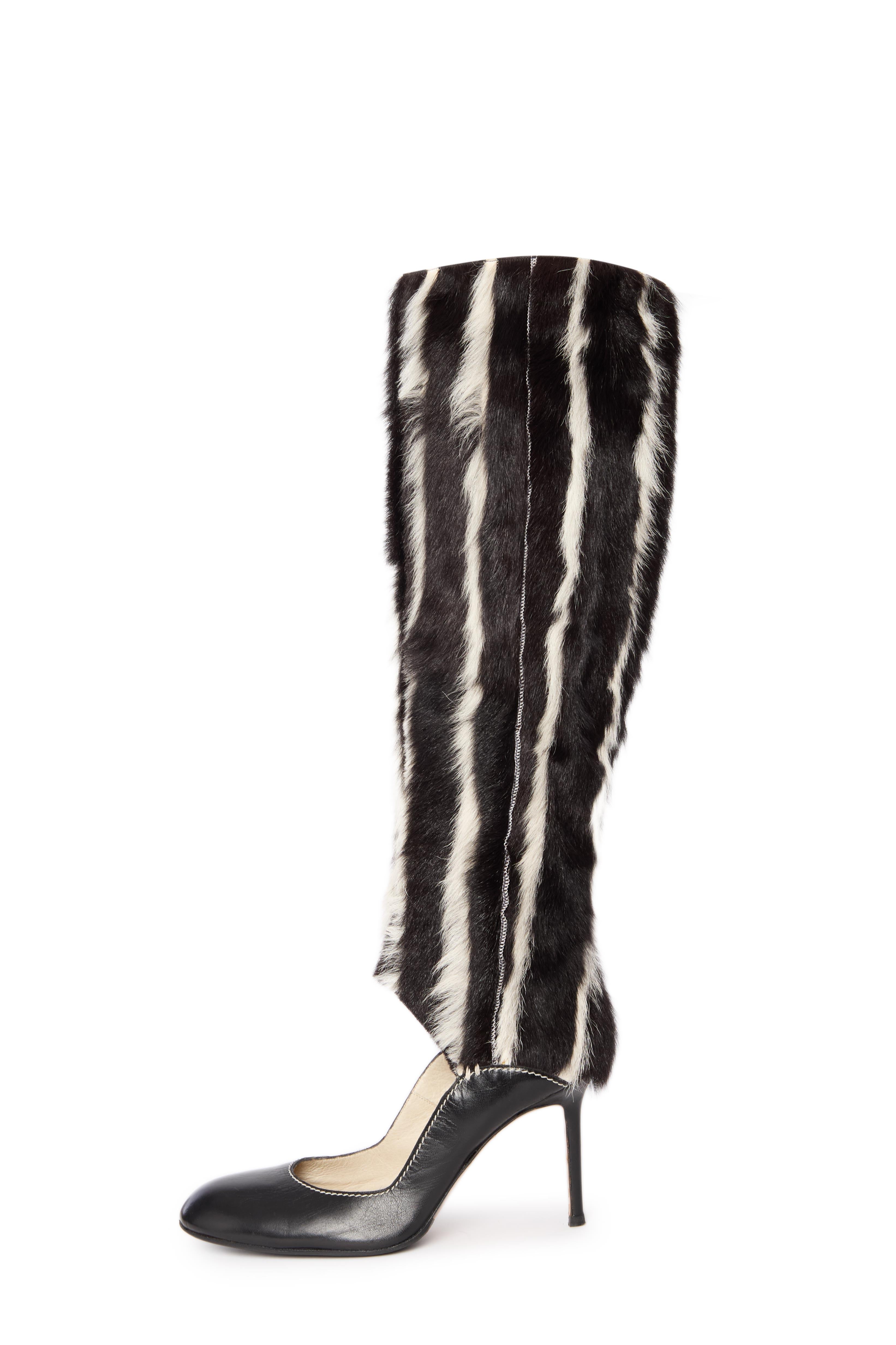 Elevate your style with these exquisite Givenchy fur heels, a bold fusion of high fashion and opulence. Featuring sleek black leather pumps adorned with luxurious striped fur cuffs, these heels redefine sophistication and daring design.
