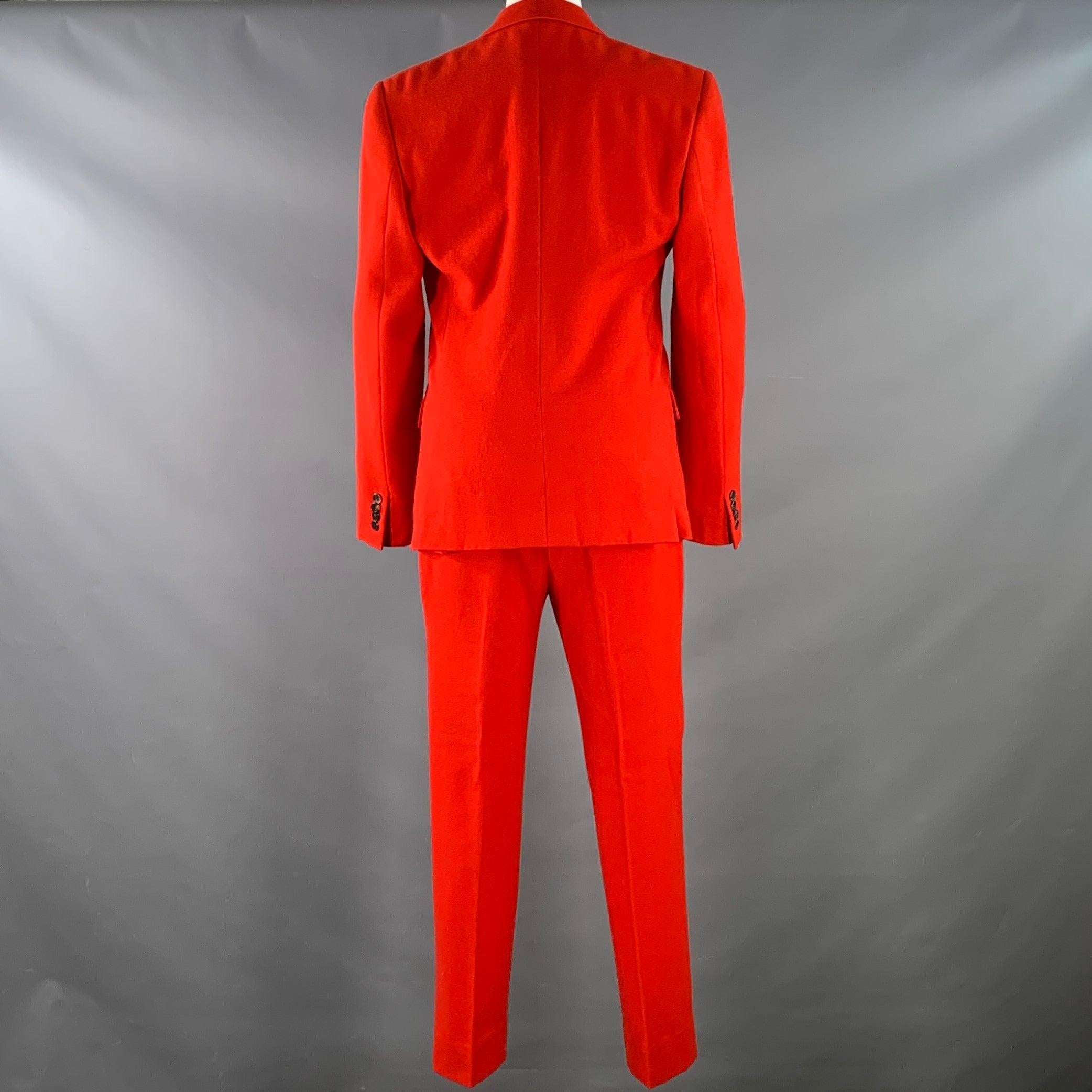 GIVENCHY FW12 suit
in a red wool cotton twill with a full liner and includes a single breasted, double button sport coat with notch lapel and matching flat front trousers. Note: this garment has been professionally altered, please double check