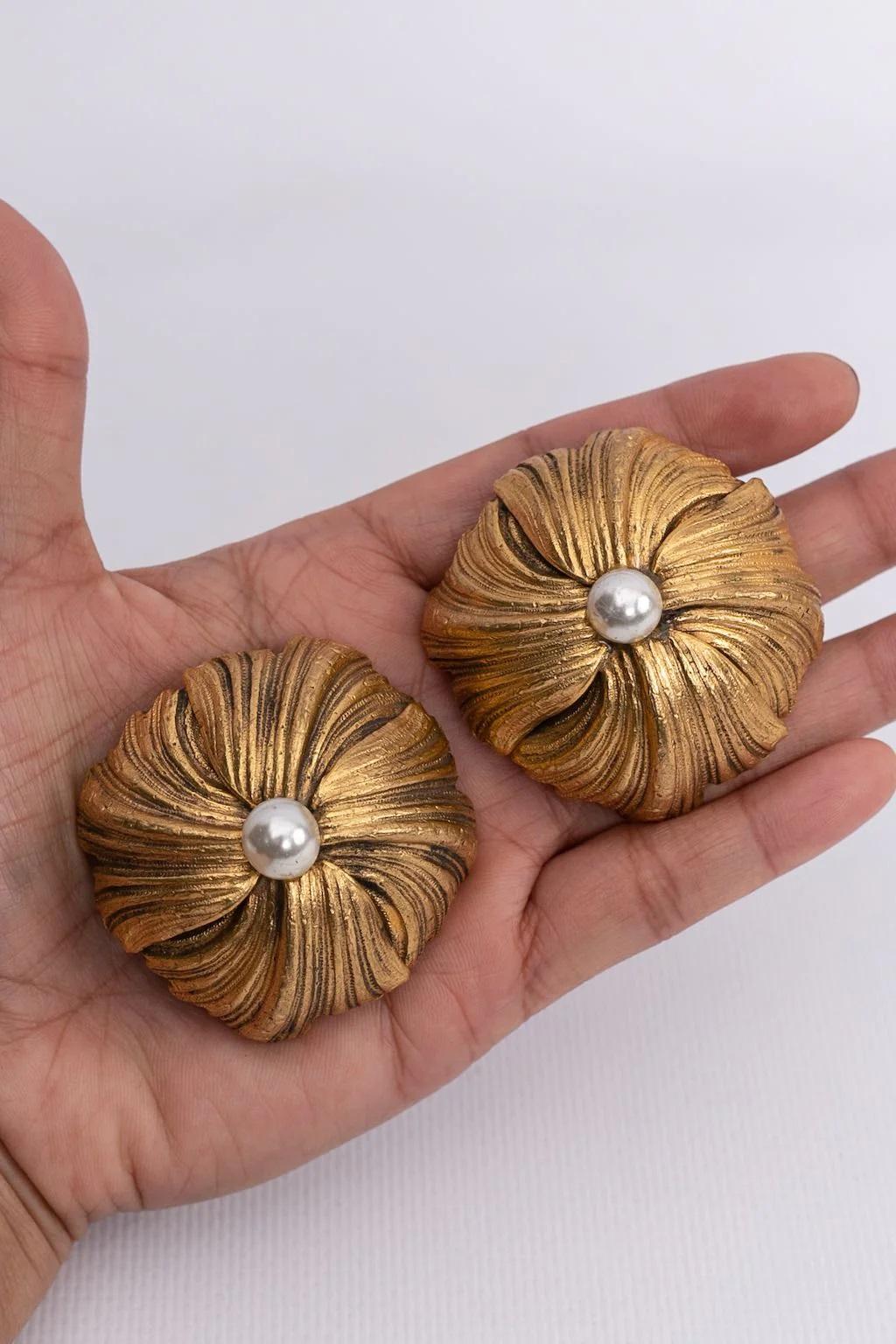 Givenchy - Gilted metal clip-on earrings centered with a faux pearl. The back is furnished with two clips.

Additional information:
Dimensions: Ø 6 cm (Ø 2.36