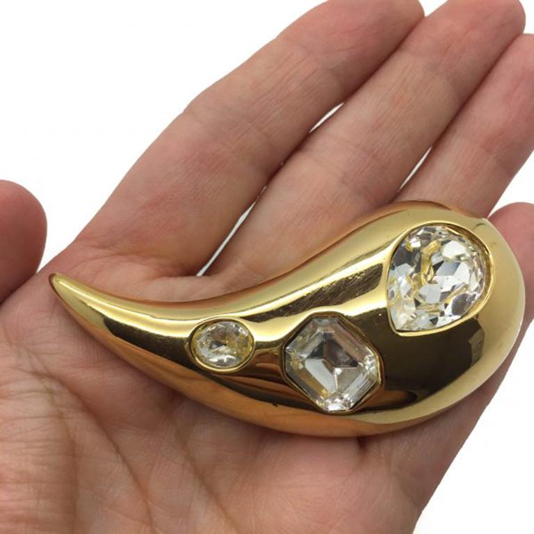 A stylish and rich looking Givenchy Vintage brooch dating to around the 1990s. The fancy cut crystal stones are truly stunning set against a backdrop of the deep shiny gold plate. In excellent vintage condition and incredibly wearable and versatile.