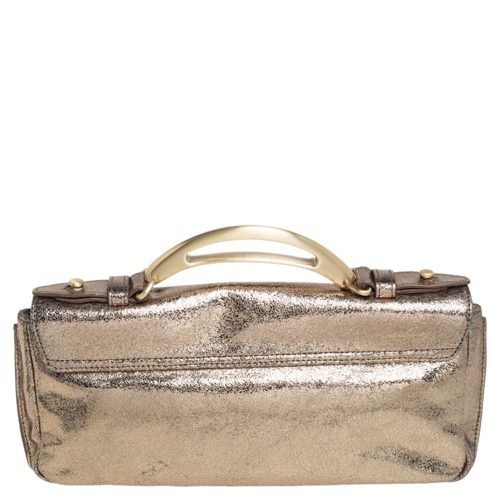 Swing this gold beauty in style. The creation is from Givenchy, made from crinkled leather and equipped with a sizeable canvas interior. The clutch features a metal handle detailed with cutouts and brand label engravings.

Includes: Original