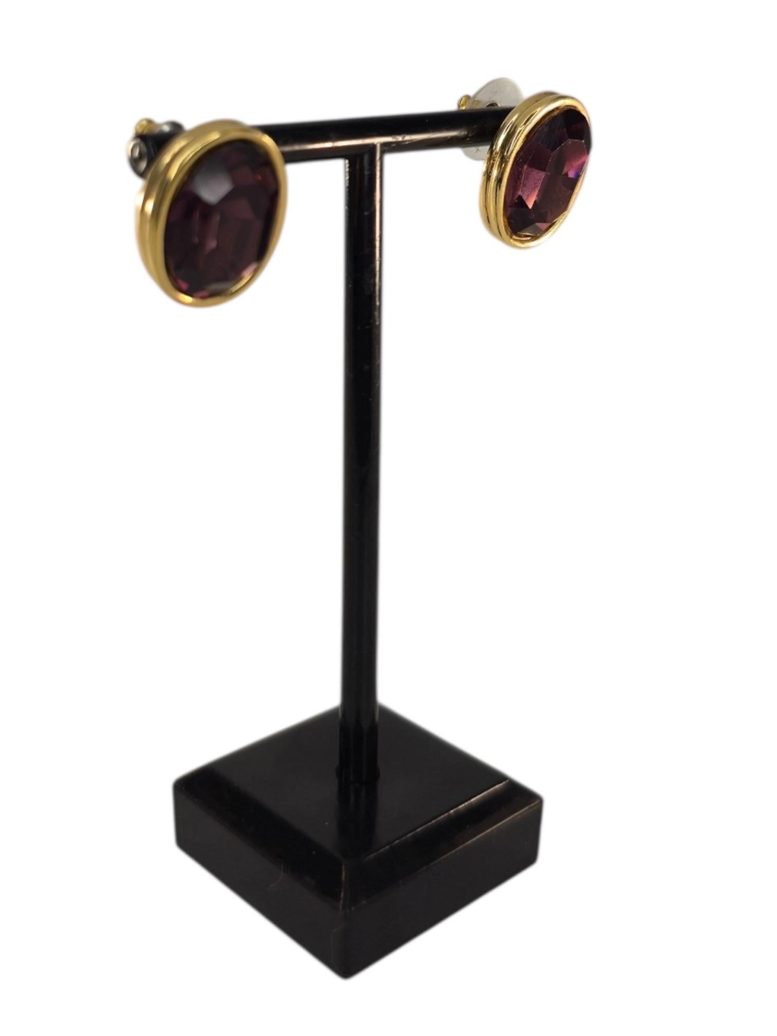 Elegant and understated with just the right amount of vintage glamour, these Givenchy stud earrings from the 1980s feature deep amethyst-hued faceted crystals set in high-polish gold-tone bezels. Designed for pierced ears, these earrings reflect the