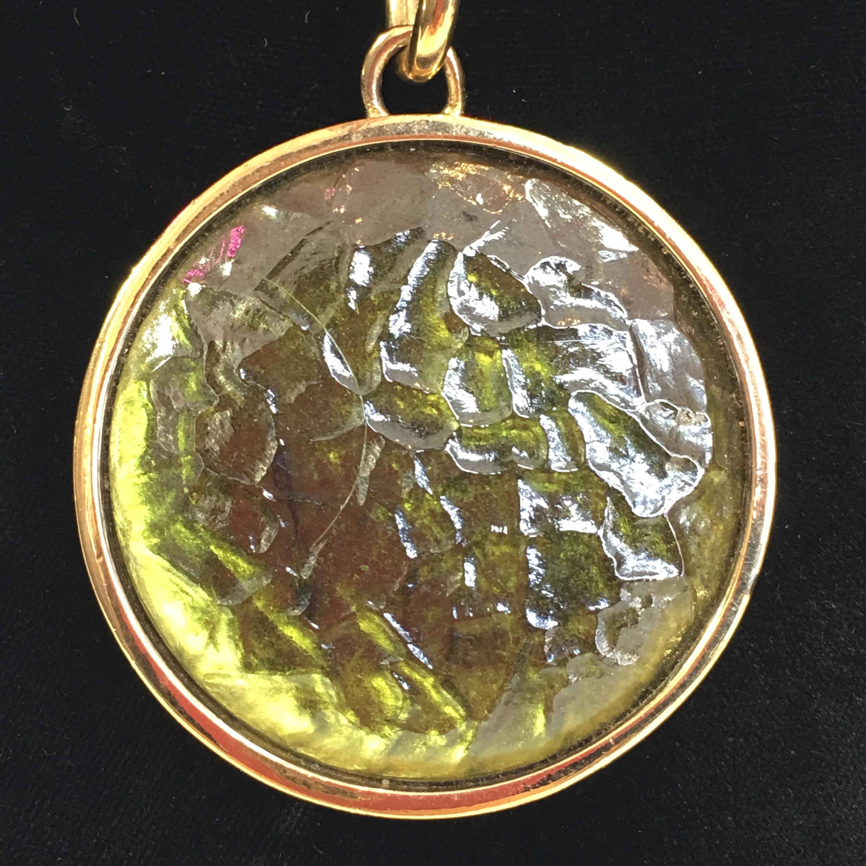 Givenchy Green Textured Art Glass Pendant with Monet Box Chain. Pendant is set in a gold plated casing.  Givenchy logo is stamped  on back of pendant. Monet box chain has Monet logo at back neck clasp.
Good vintage condition.

Measurements are as