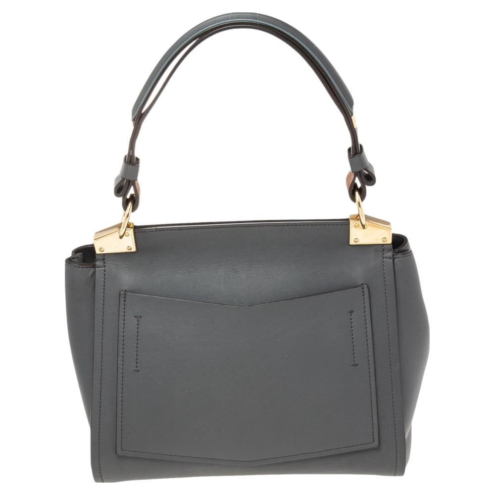 This top handle bag from Givenchy is crafted from grey leather. The bag features an adjustable shoulder strap, a top handle, a logo lock on the flap, and a leather-lined interior. This creation is easy to carry on any day.

