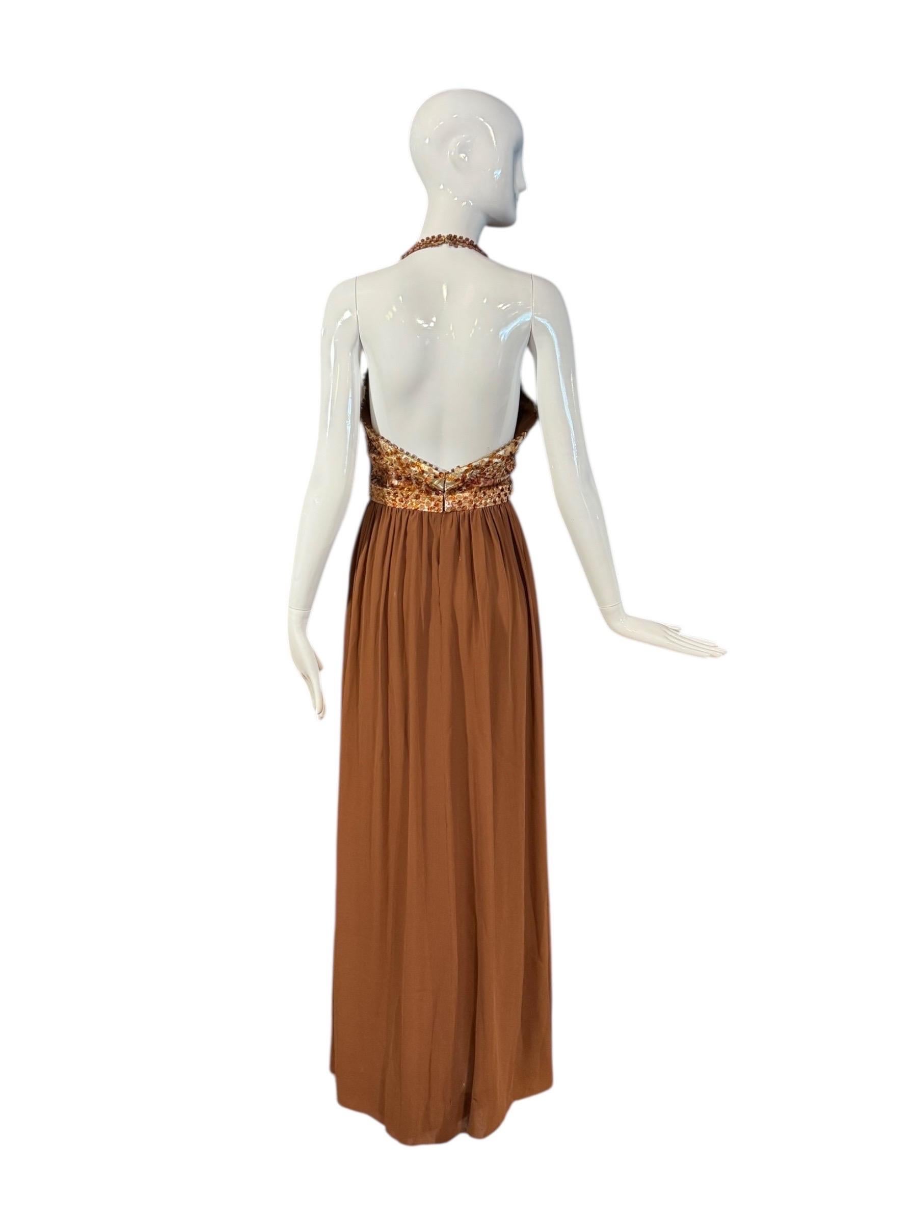 Un abito haute couture da museo di Hubert de Couture, caratterizzato da un corpetto cavezza tempestato di paillettes e paillette color ambra e da una gonna in chiffon di seta morbidamente arricciata in un ricco color marrone. Questo raro ensemble