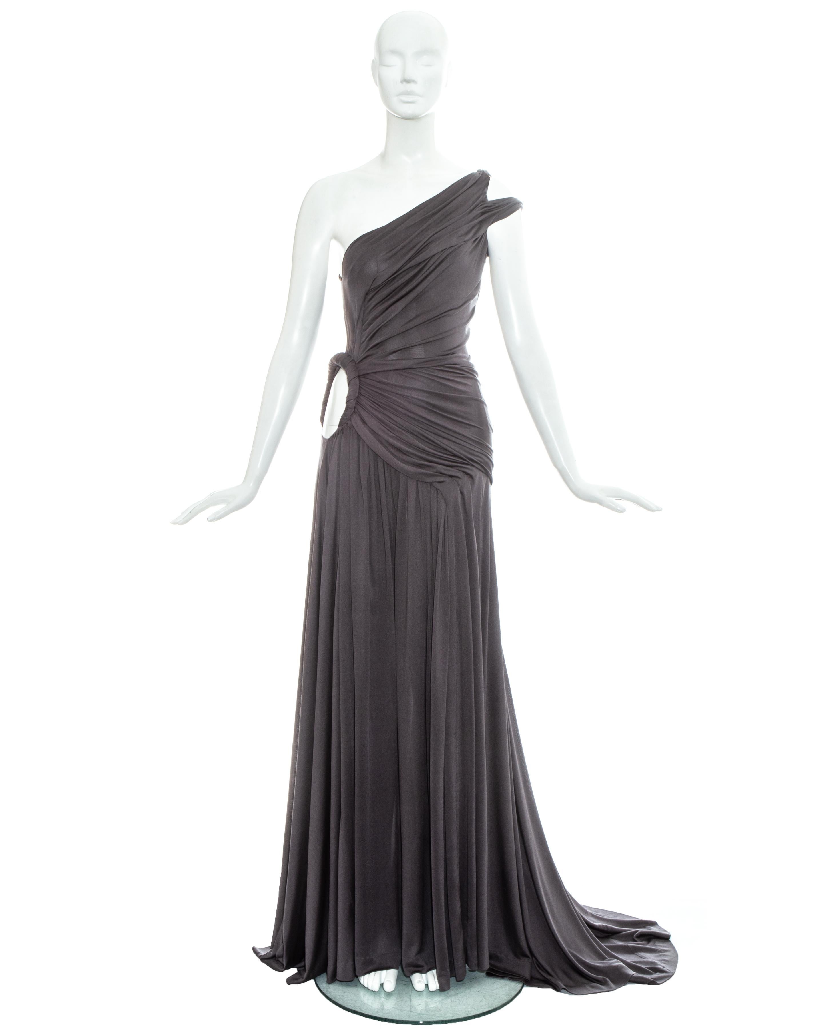 Givenchy Haute Couture, grey silk jersey trained evening gown with pleated bodice, circular cut out on the hip, two straps on one shoulder and hidden zip fastening on side seam. Sold with matching silk chiffon pleated mid-length cape with ribbon