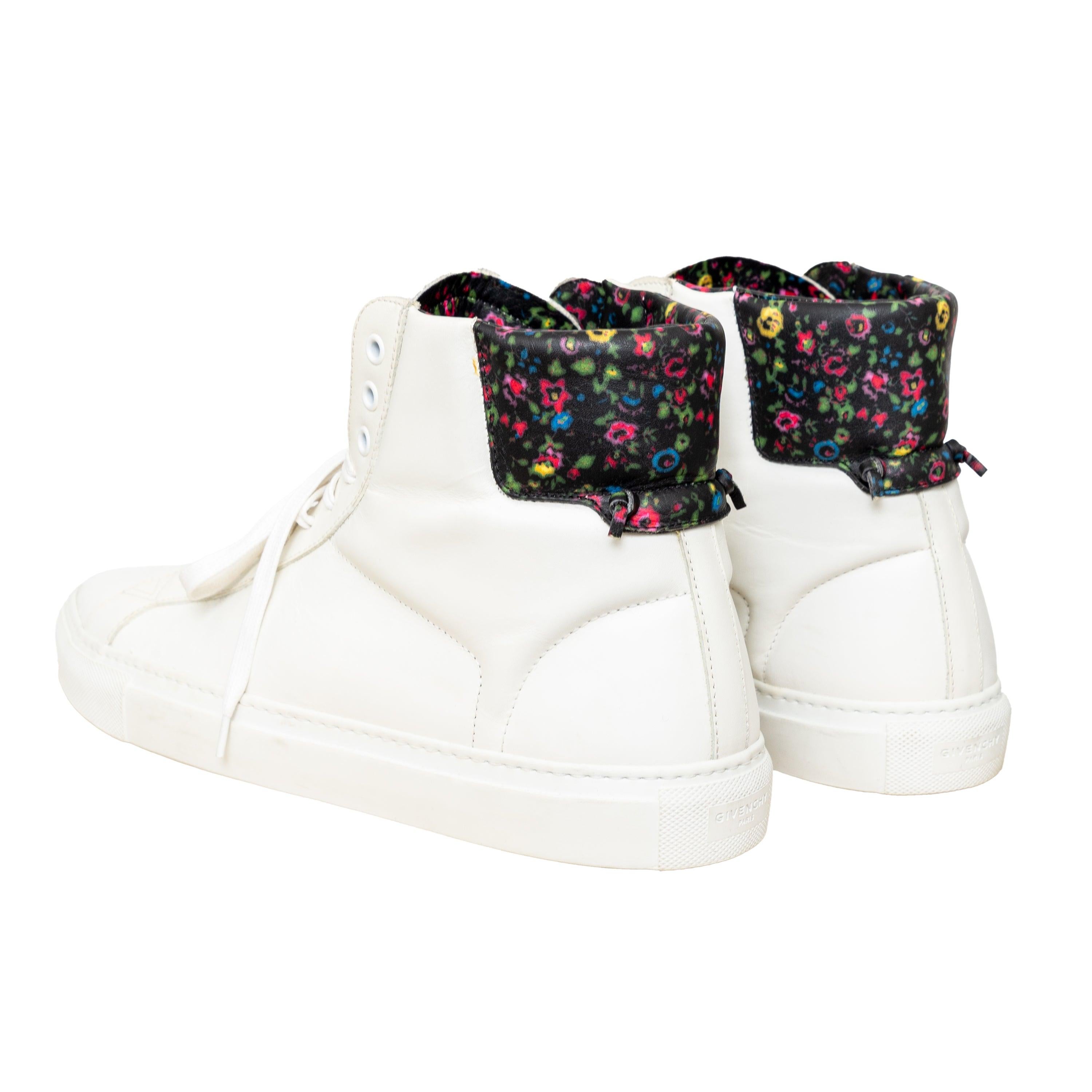 Elevate your shoe game with the Givenchy Leather High Top Sneakers. Crafted in white leather, these sneakers feature a colorful floral pattern on the back tab, adding a touch of playfulness. The subtle logo emblem adds a touch of brand flair.
