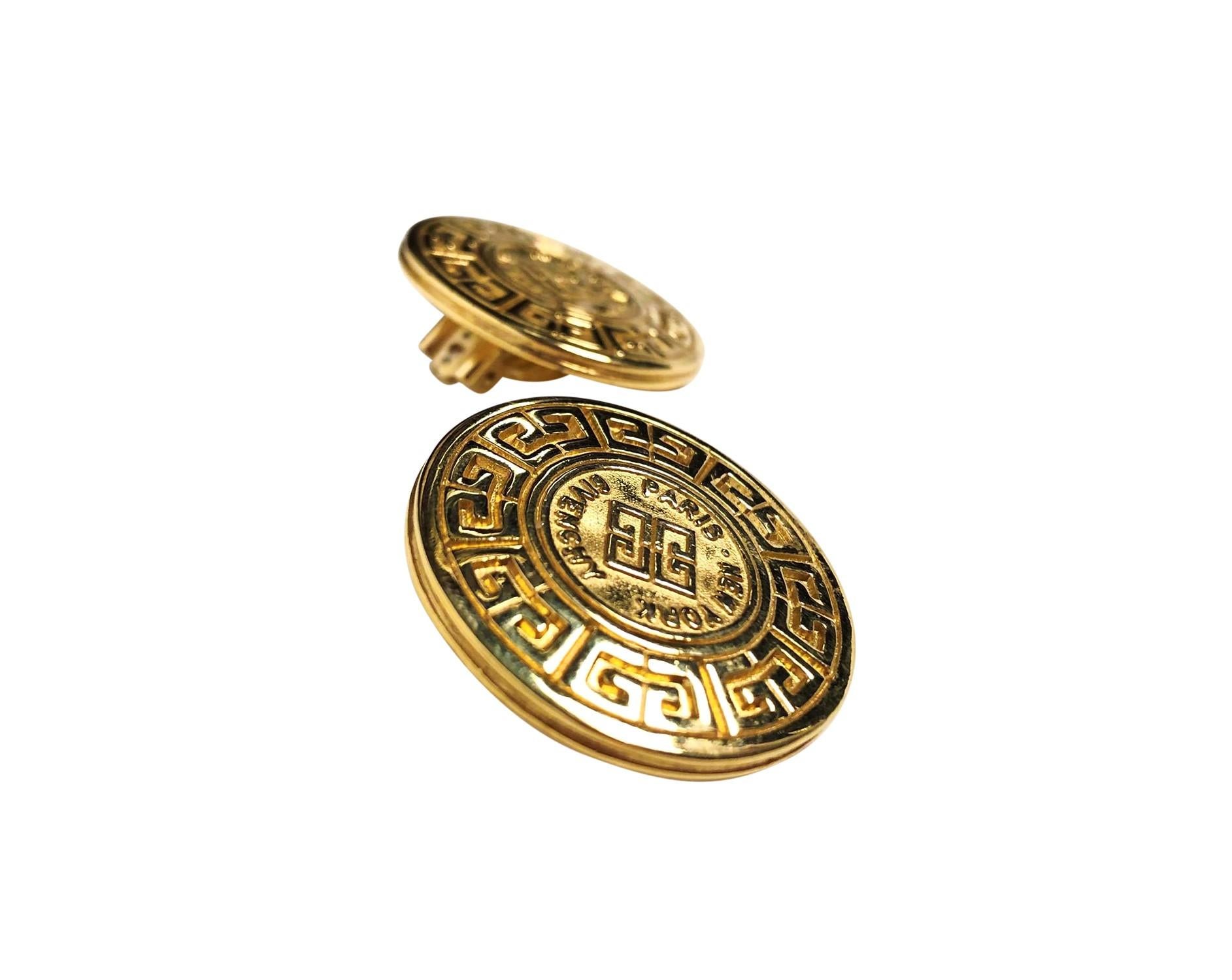 Iconic vintage Givenchy medallion clip on earrings in gold toned metal. These earrings feature Givenchy logo embellishments with GIVENCHY PARIS NEW YORK engravings on front and backs of earrings. 
3.3cm in diameter