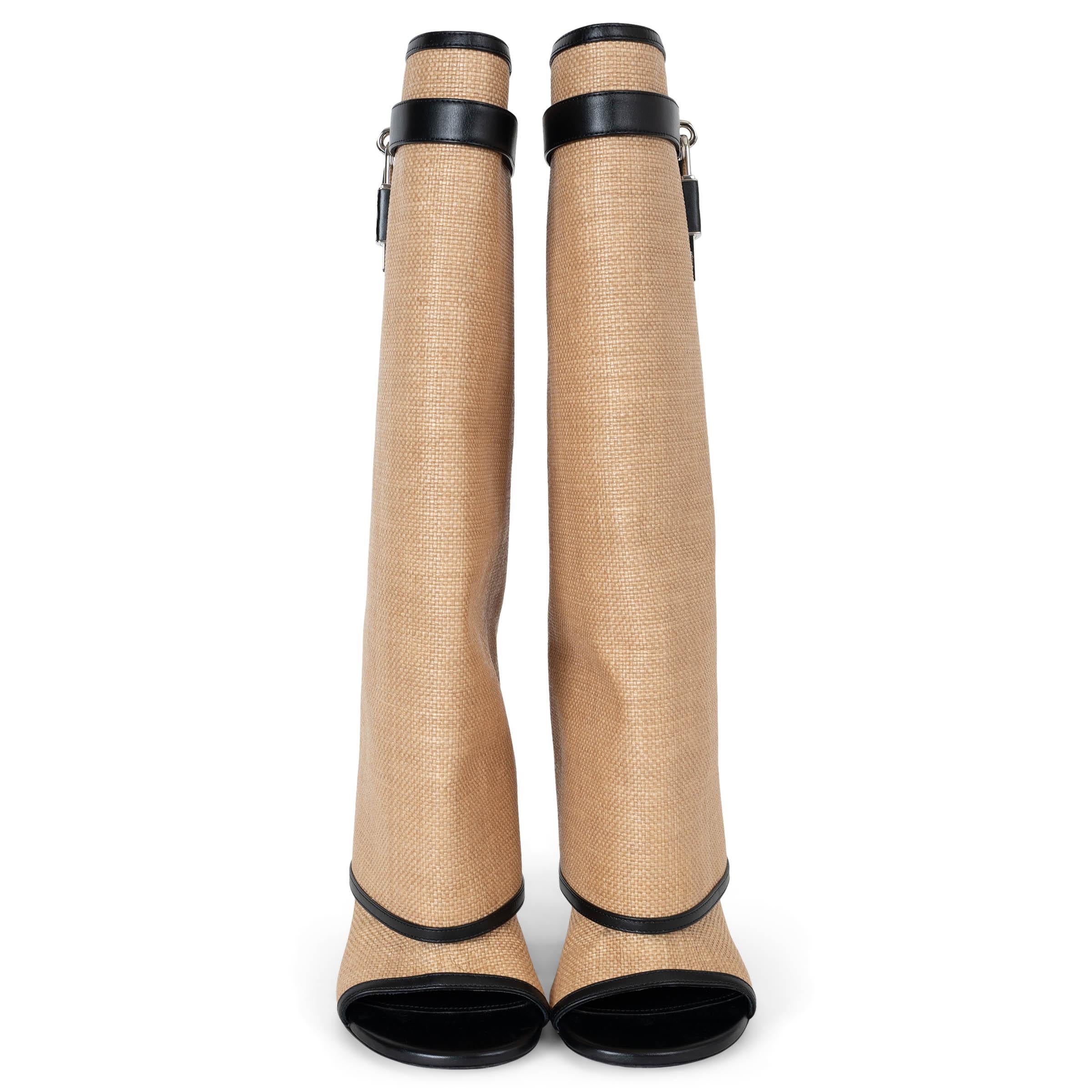 This 100% authentic Givenchy Shark Lock boots in natural raffia with black leather trims offer a striking fusion of texture and sophistication. Featuring a knee-high, wide-fit shaft, they are adorned with a leather strap, silver-tone clasp, and