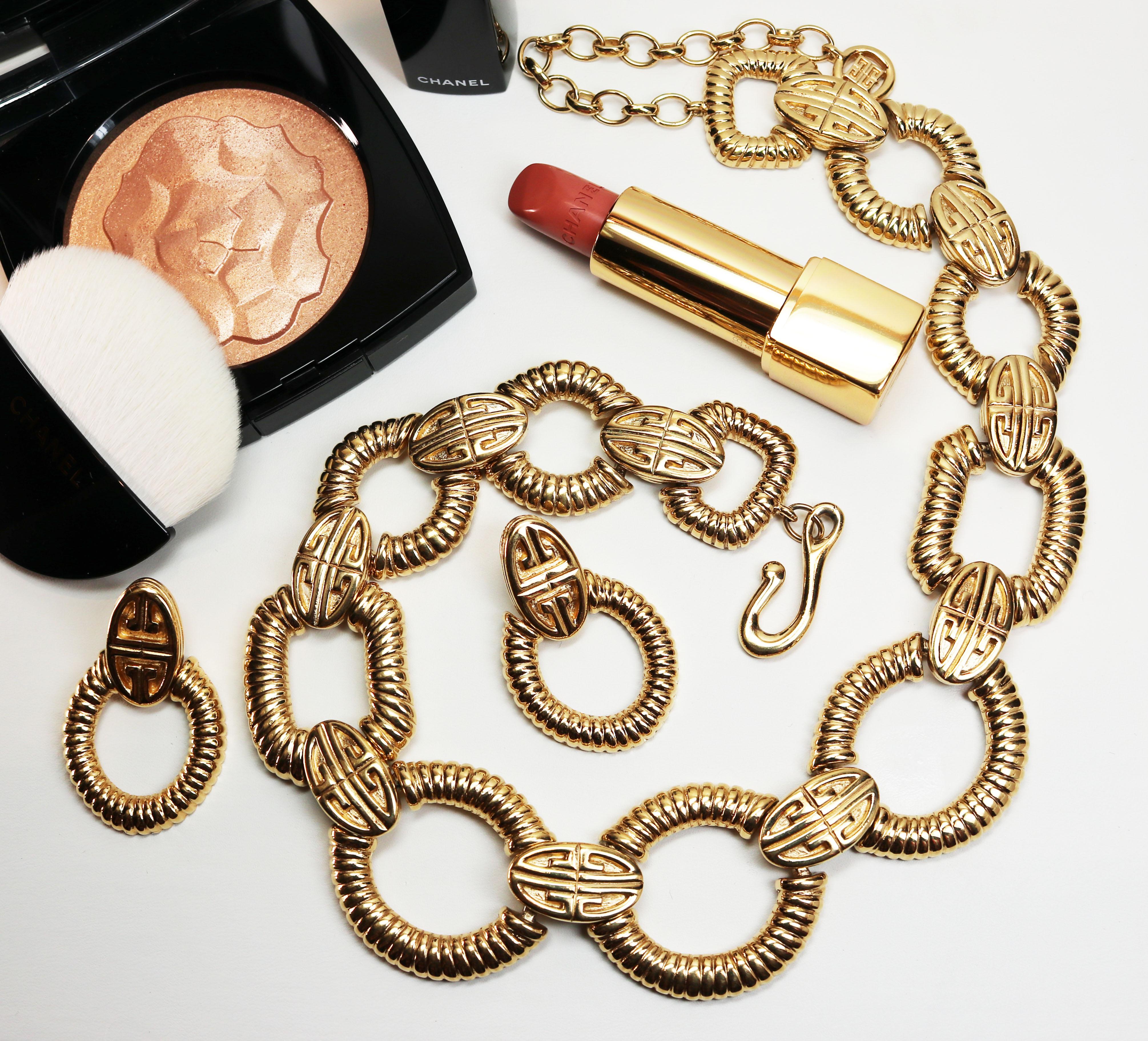 These pieces feature the iconic Givenchy logo on gold plated, oval shaped links with articulating, ribbed hoops that form a very unique doorknocker style. The earrings are signed GIVENCHY on an oval cartouche on the reverse, measure 1.75