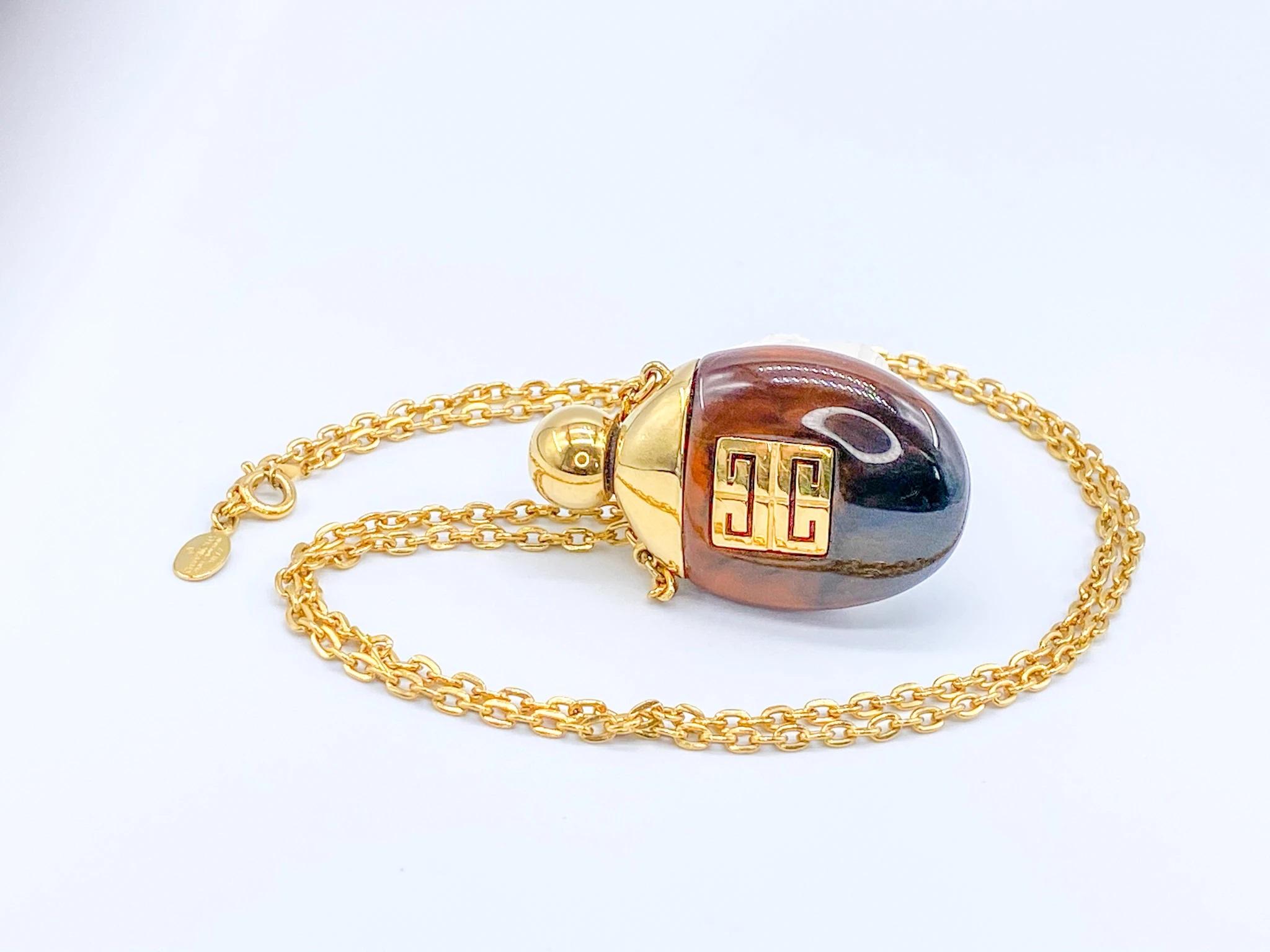 Givenchy 1970s Perfume Bottle Pendant Necklace Vintage. 

Givenchy 1977 vintage faux tortoiseshell perfume bottle necklace. Features the iconic Givenchy logo, first introduced in the 1970's. A classic and iconic piece from Givenchy's heyday. 

Fully