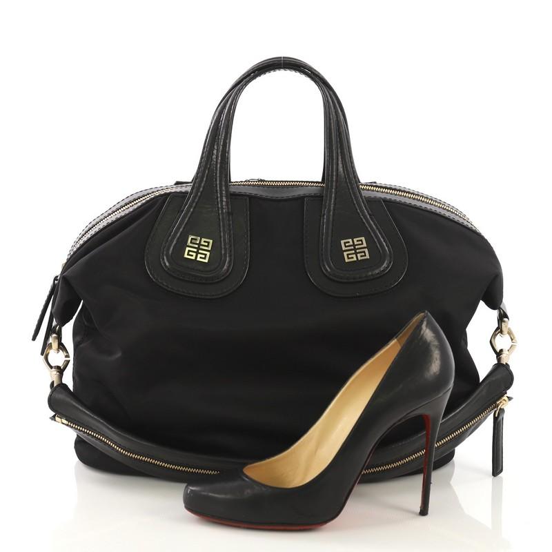 This Givenchy Nightingale Satchel Studded Nylon Medium, crafted in black nylon, features multiple stud details, dual top handles with logo emblem, and gold-tone hardware. Its zip closure opens to a black fabric interior with slip and zip pockets.