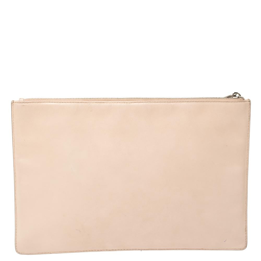 Embrace the ongoing trends with this smart clutch by Givenchy. This beige-hued creation features the label's name printed on the front. The top zip closure opens to a spacious canvas-lined interior.

