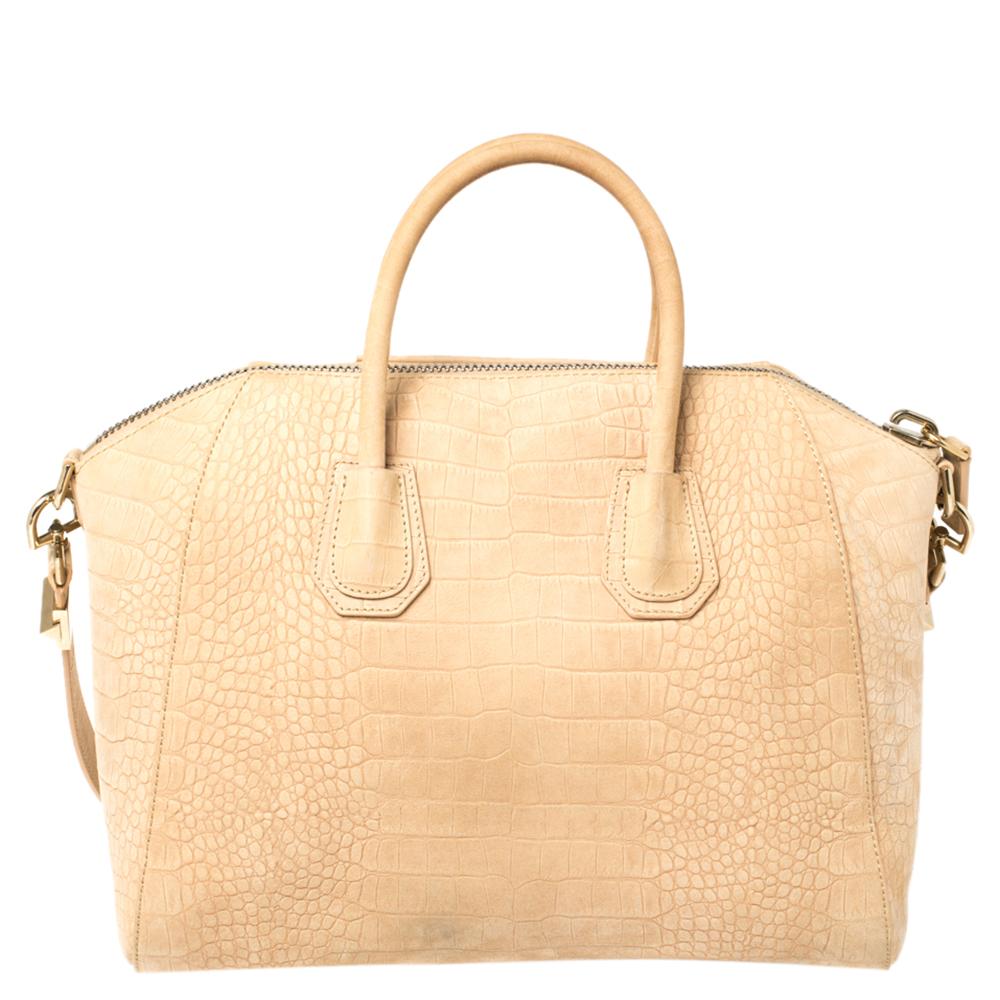 Made in Italy, and loved by women worldwide is this beautiful Antigona satchel by Givenchy. It has been crafted from Nubuck and shaped elegantly. The beige bag has a top zipper that reveals a fabric interior and it is held by two top handles and a