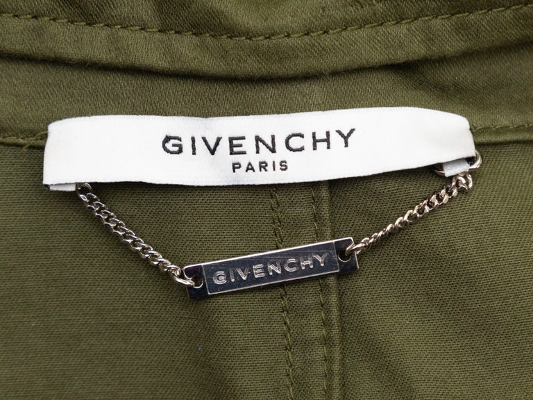Product Details: Olive and multicolor cotton hooded parka by Givenchy. Dual hip pockets. Drawstring at waist and at hem. Graphic print at back. Concealed closures at center front. 36
