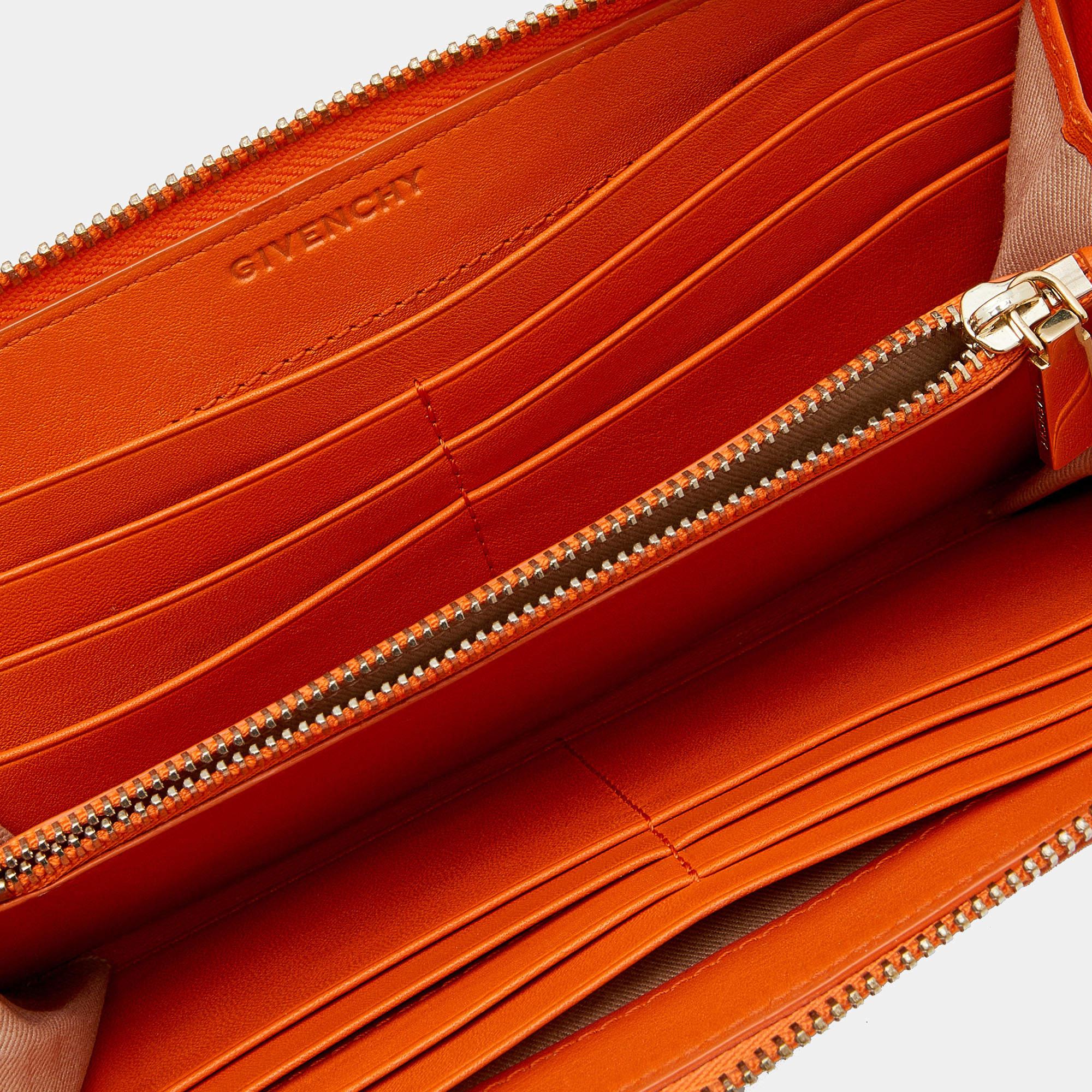 Il portafoglio di Givenchy è un'aggiunta pratica e di tendenza al tuo guardaroba. L'esterno in tela spalmata arancione e grigia è impreziosito da una targhetta Givenchy. La chiusura con zip dorata assicura la borsa. Il portafoglio ha un ampio spazio