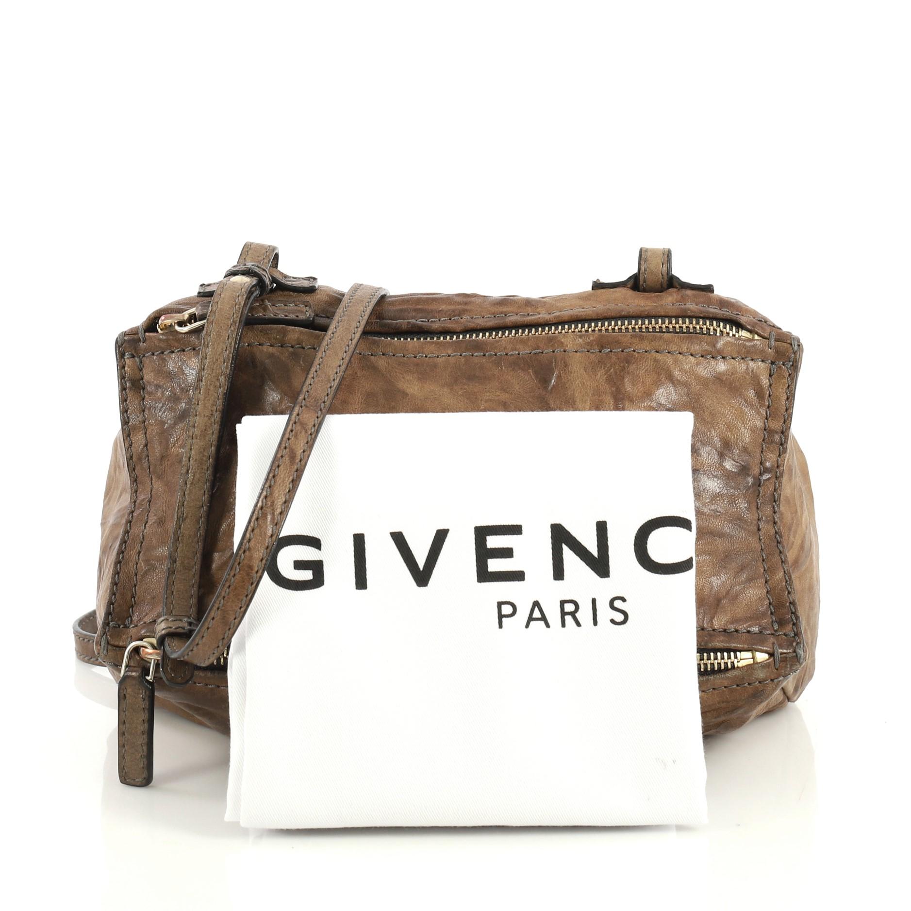 This Givenchy Pandora Bag Distressed Leather Mini, crafted from brown distressed leather, features a leather strap, exterior zip pocket, and gold-tone hardware. Its two-way zip fastenings open to a black canvas interior with side zip pocket.