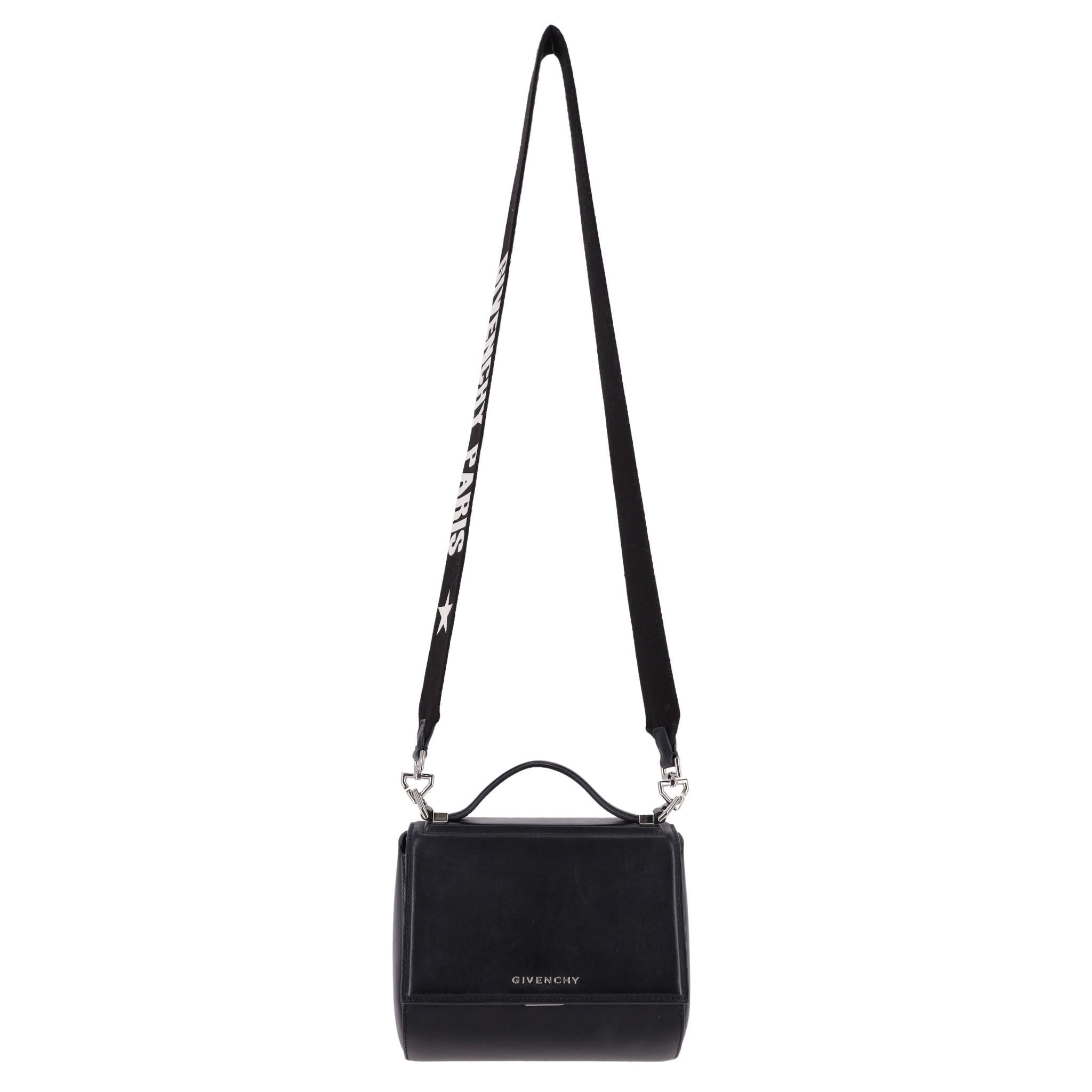 Givenchy Pandora Box Logo Leather Bag

Boxy messenger bag designed with front flap clasp closure and detailed with silver 'Givenchy' logo lettering.

Featuring black canvas, wide detachable shoulder strap styled with 'Givenchy Paris' inscription in