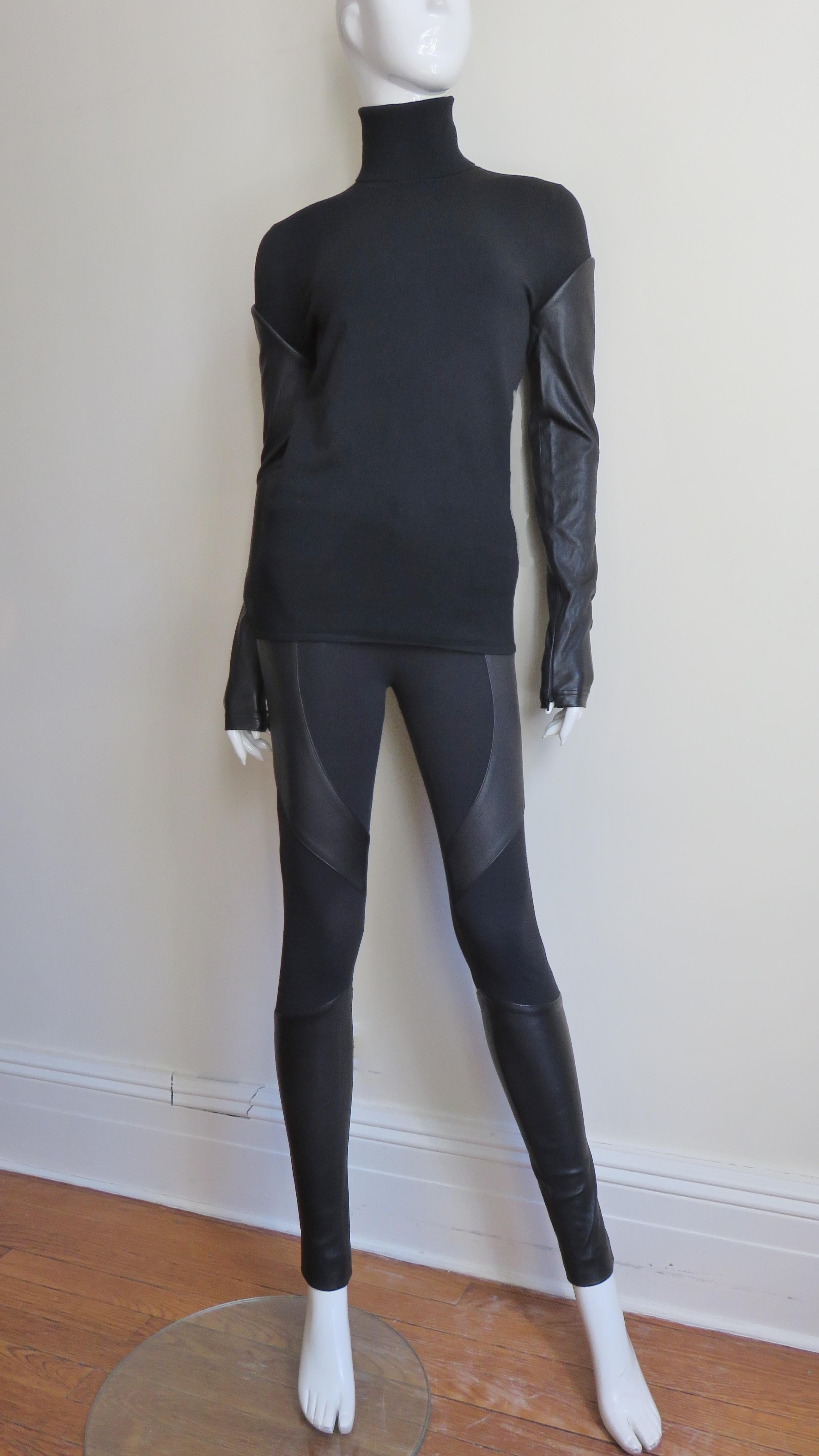 A fabulous black knit and leather 2 piece pant and top set from Givenchy.  It consists of a turtleneck top with long leather sleeves with zipper cuffs.  The pants have a zipper front, mid rise waistband, 2 front pockets and insets of leather at the