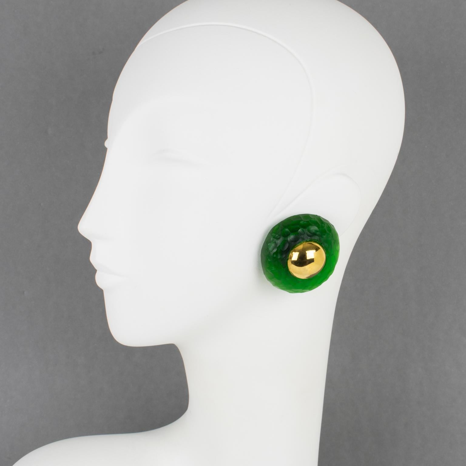 These very stylish Givenchy Paris clip-on earrings feature a dimensional domed shape, with carved and textured translucent green Lucite topped with gilt metal cabochons. They are signed with the 