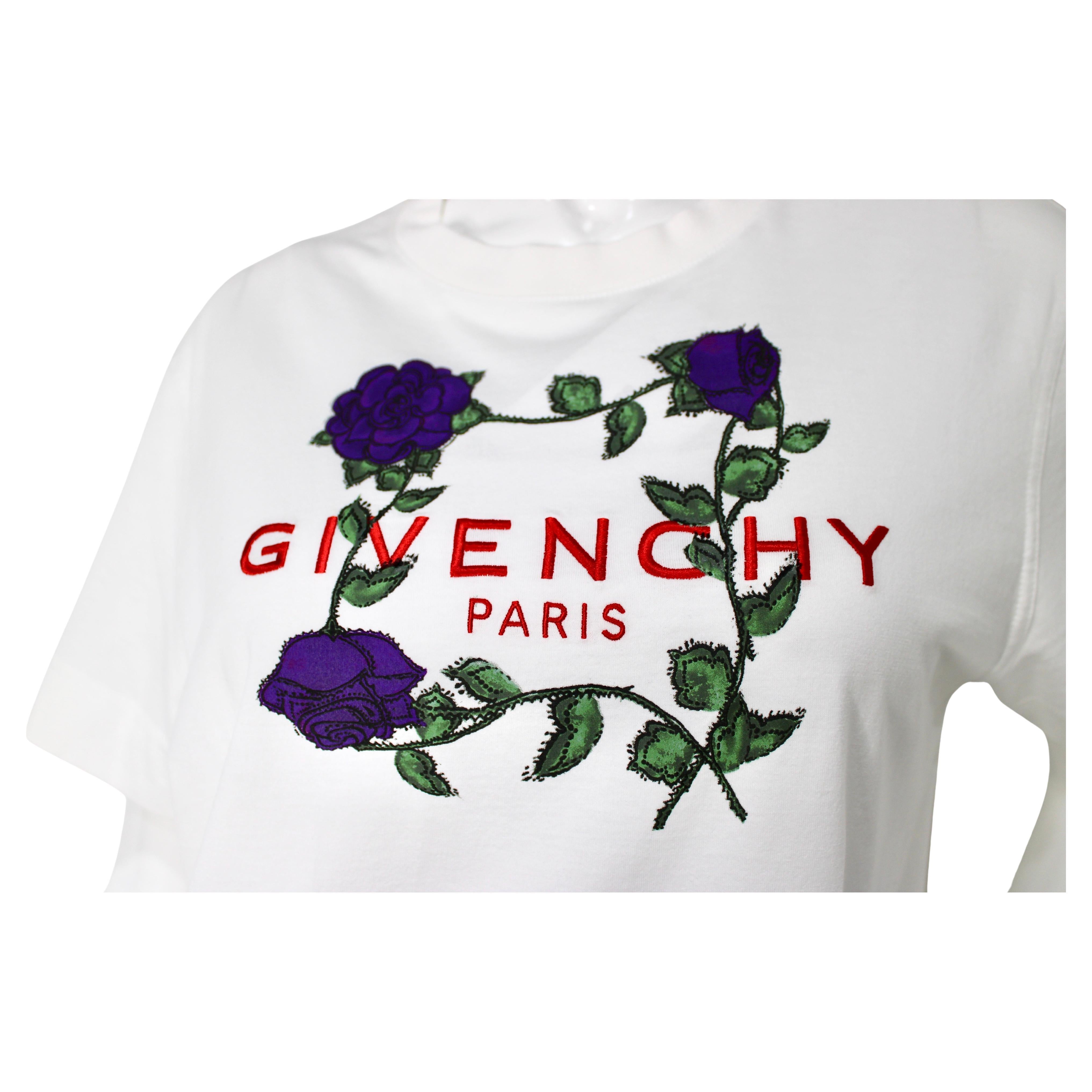 La T-Shirt Givenchy Paris Purple Rose Print è un capo di grande effetto e stile che unisce senza sforzo il lusso all'eleganza casual. Realizzata in cotone di alta qualità, questa maglietta presenta vivaci rose viola su una t-shirt bianca che incarna