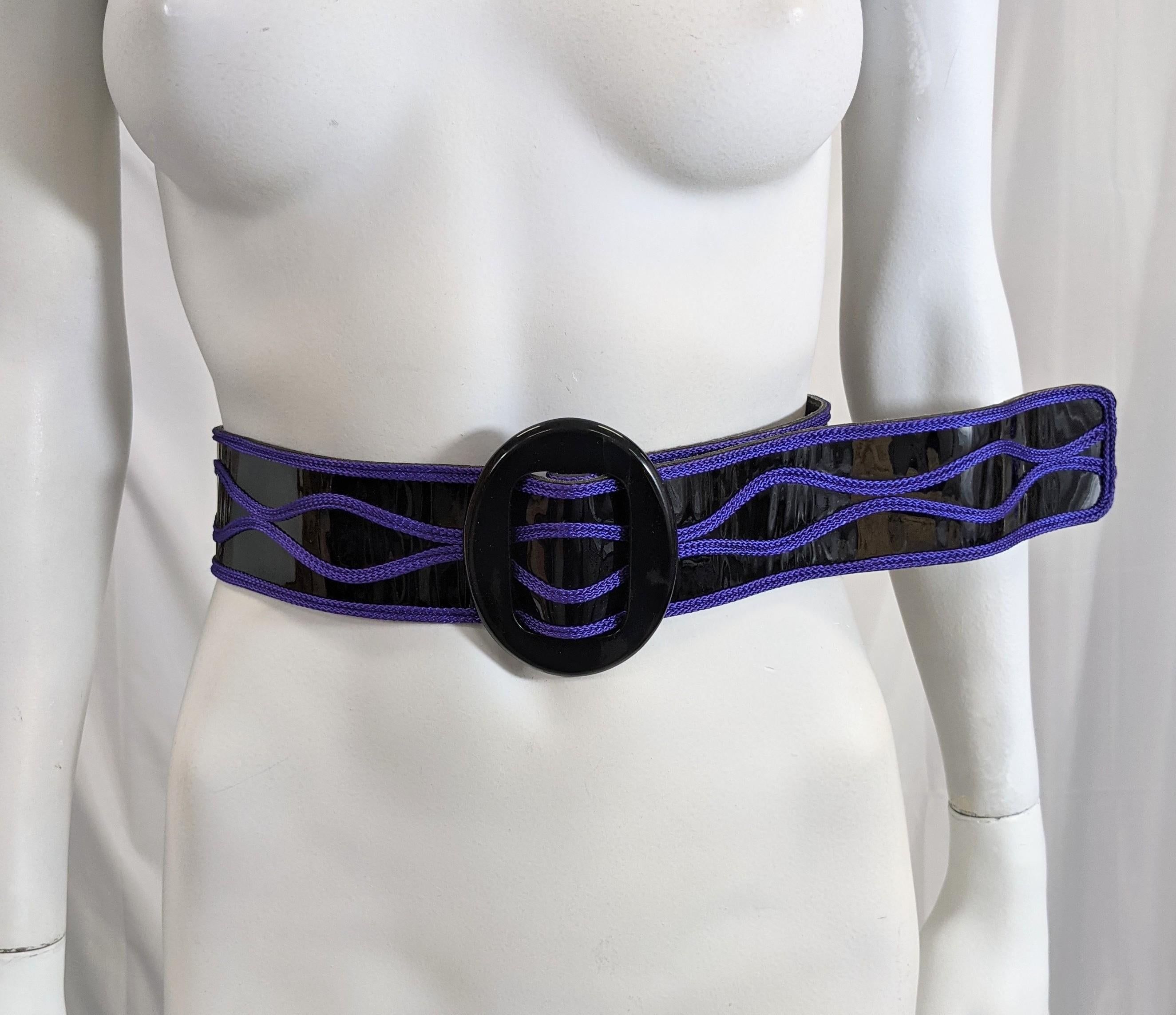 Striking Givenchy belt of black patent leather with vibrant purple soutache trim and large oval bakelite buckle. Slides and holds with no hoods or eyes. 
1980's France. 35
