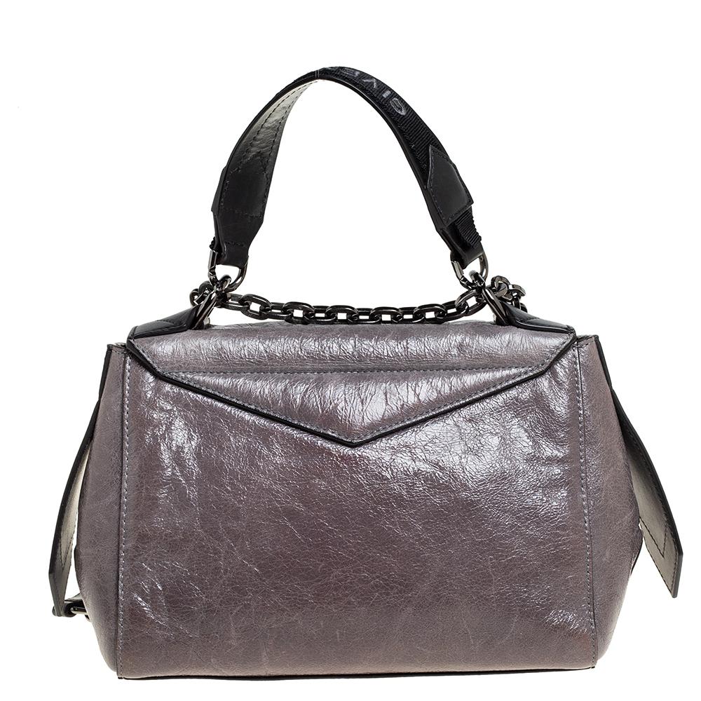 This small ID bag by Givenchy is a petite beauty with an understated charm and winsome appeal. The subtle grey hue adorns its aged leather exterior and it is held by a logo-detailed top handle as well as a shoulder strap. The logo-accented front