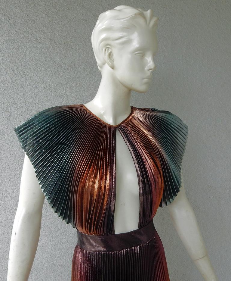 A Givenchy accordian pleated silk evening gown.  Fashioned in shimmering hues of orange, gold, silver and rose.   A plunging neckline enhanced by short sleeves.  Front and back fashioned with a matching cut.  Might I add .... looks fabulous on