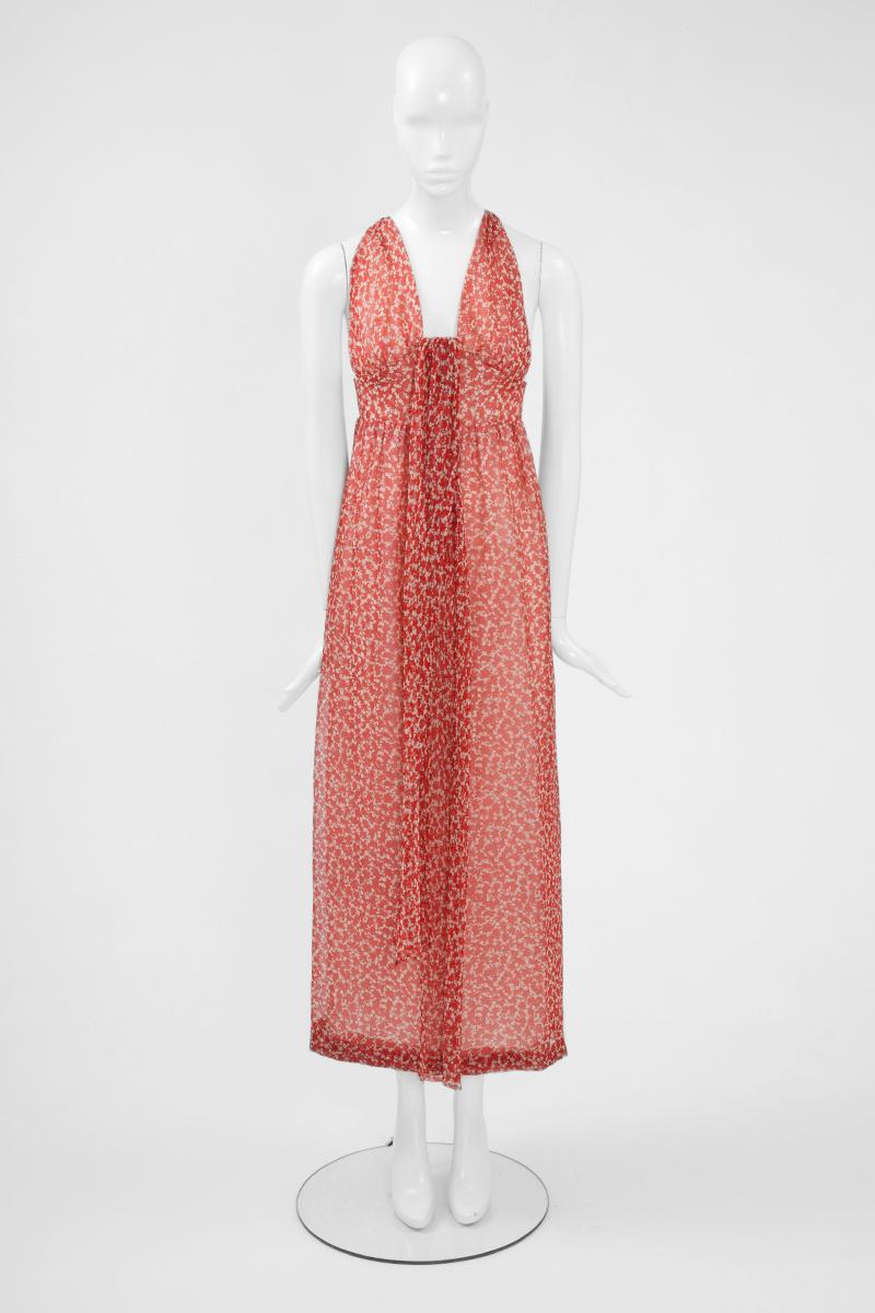 Wonderful 70's silhouette with this Givenchy maxi dress. Made of airy silk chiffon featuring a red and white graphic print, the dress has a deep plunging neckline at the front and refined straps that cross over at the back. Flattering empire waist