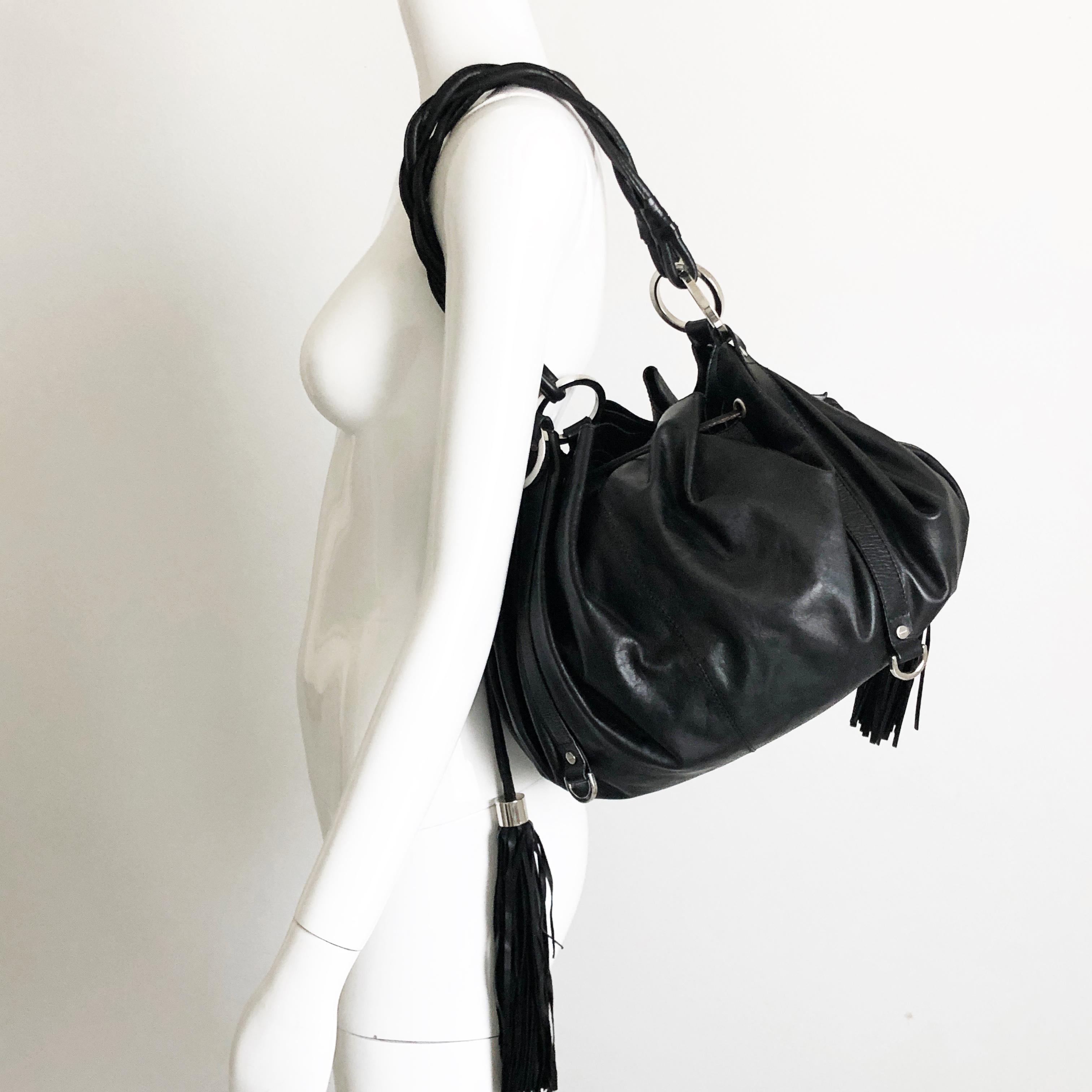 Authentic, preowned Givenchy black leather pumpkin tote or hobo bag, from mid 2000s. Silver hardware/unlined interior w/one attached leather pouch/drawstring closure with tassels. Classic shape & style. Preowned with some signs of prior use & wear: