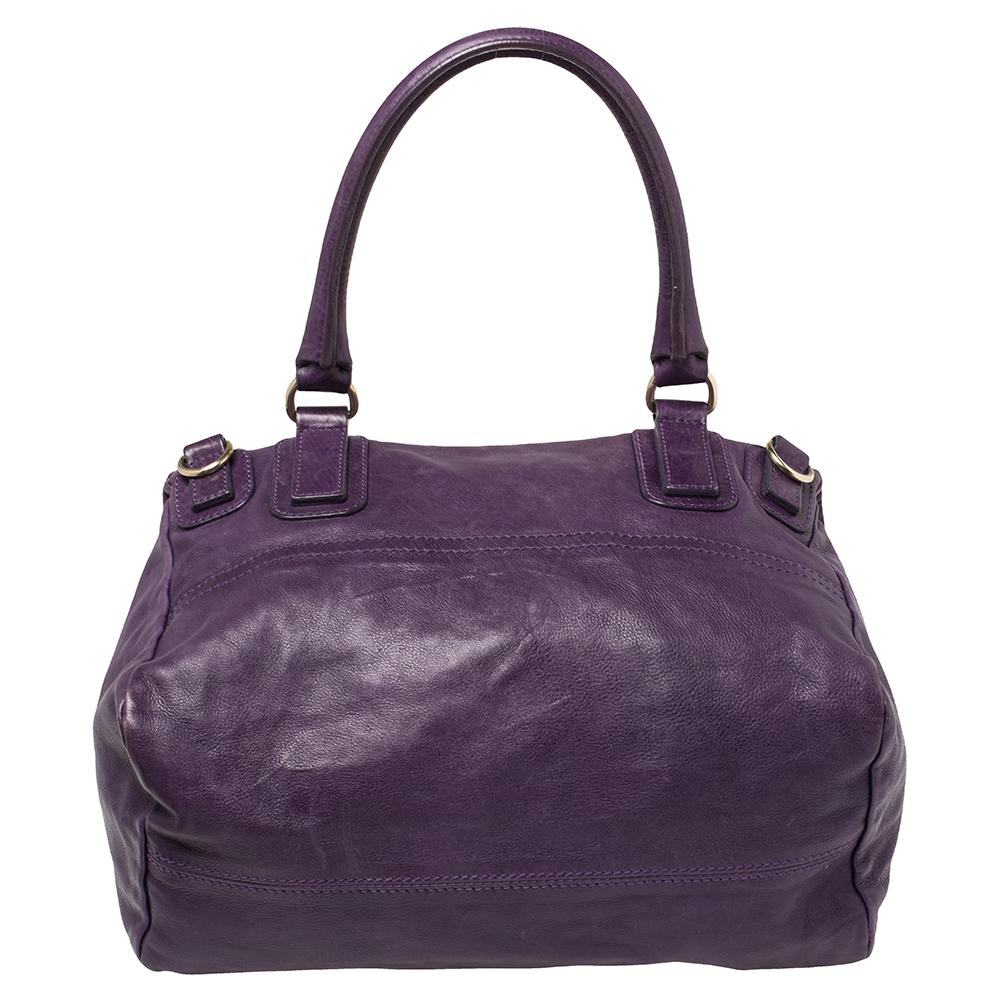 This bag from Givenchy in purple is stylish and functional. Crafted from leather, the Pandora bag features double zipper fastenings and a single handle. The insides are fabric-lined and the bag is complete with the brand logo on the front, gold-tone