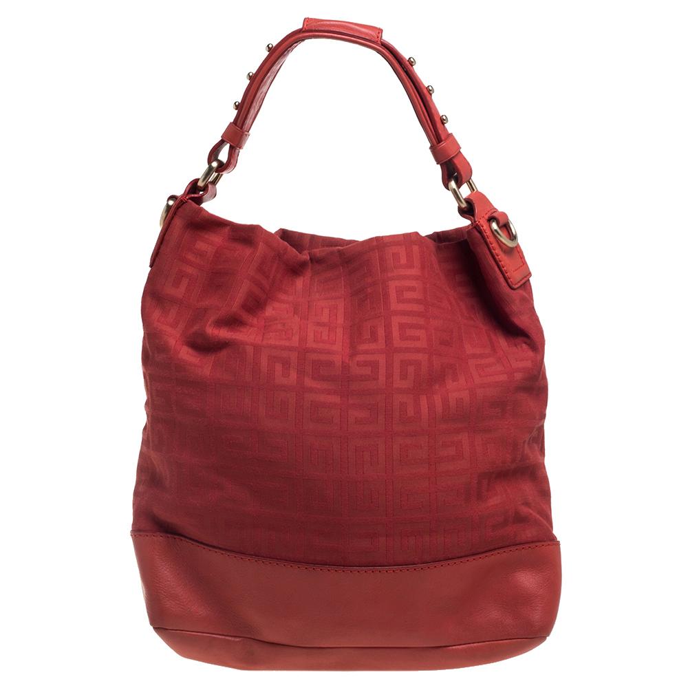 Designed in a red canvas body with logo print, this Givenchy bag comes with a leather-trimmed base and a top handle. It comes with a detachable shoulder strap and opens to a spacious interior. This bag is perfectly proportioned so that you can carry