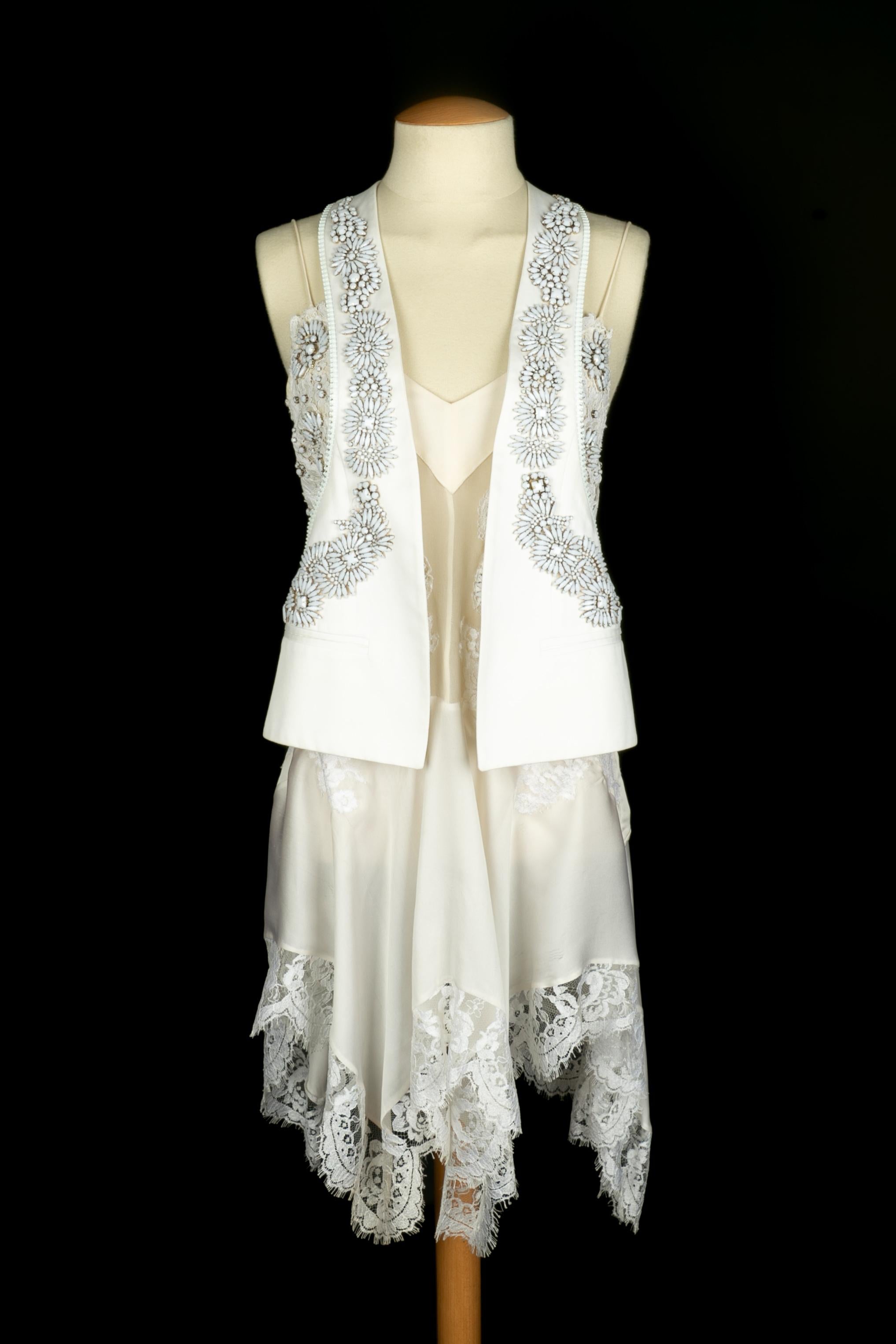 GIVENCHY - (Made in Italy) Conjunto de tela blanca y encaje adornado con brillantes blancos, compuesto por un vestido vaporoso y un cárdigan. Talla 38FR indicada.

Estado:
Buen estado

Dimensiones:
Chaqueta: Pecho: 40 cm - Largo: 56 cm // Vestido: