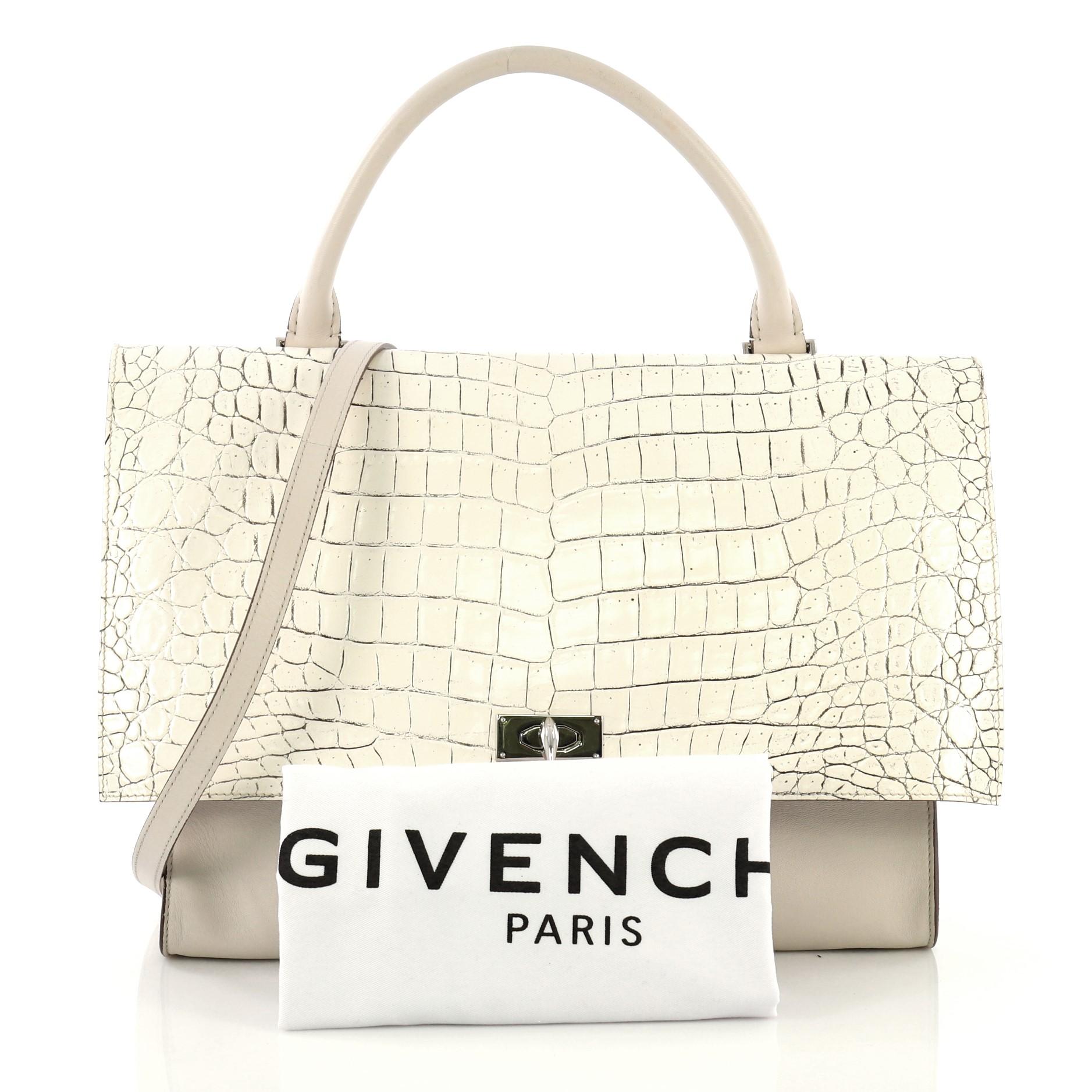 This Givenchy Shark Convertible Satchel Crocodile Embossed Leather Medium, crafted from gray and neutral leather, features a rolled leather handle, signature shark tooth-shaped twist lock, protective base studs, and silver-tone hardware. Its