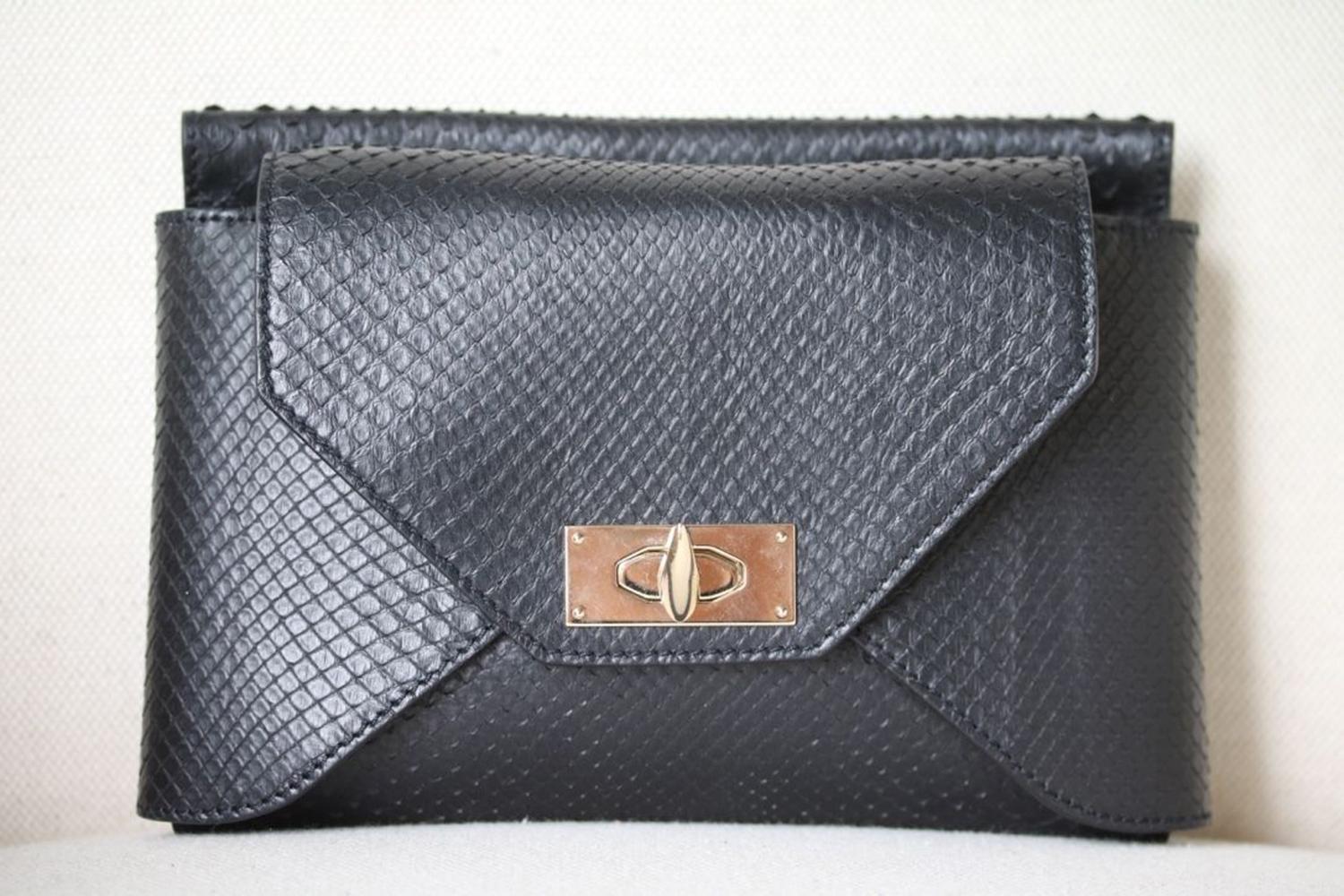 Large 'Shark Tooth' clutch in black leather by Givenchy. Black python leather (Lamb). Signature shark twist lock-fastening flap pocket, zipped pocket, gold hardware. Concealed magnetic fastening at top. 

Dimensions: Approx. 22 x 15 x 3