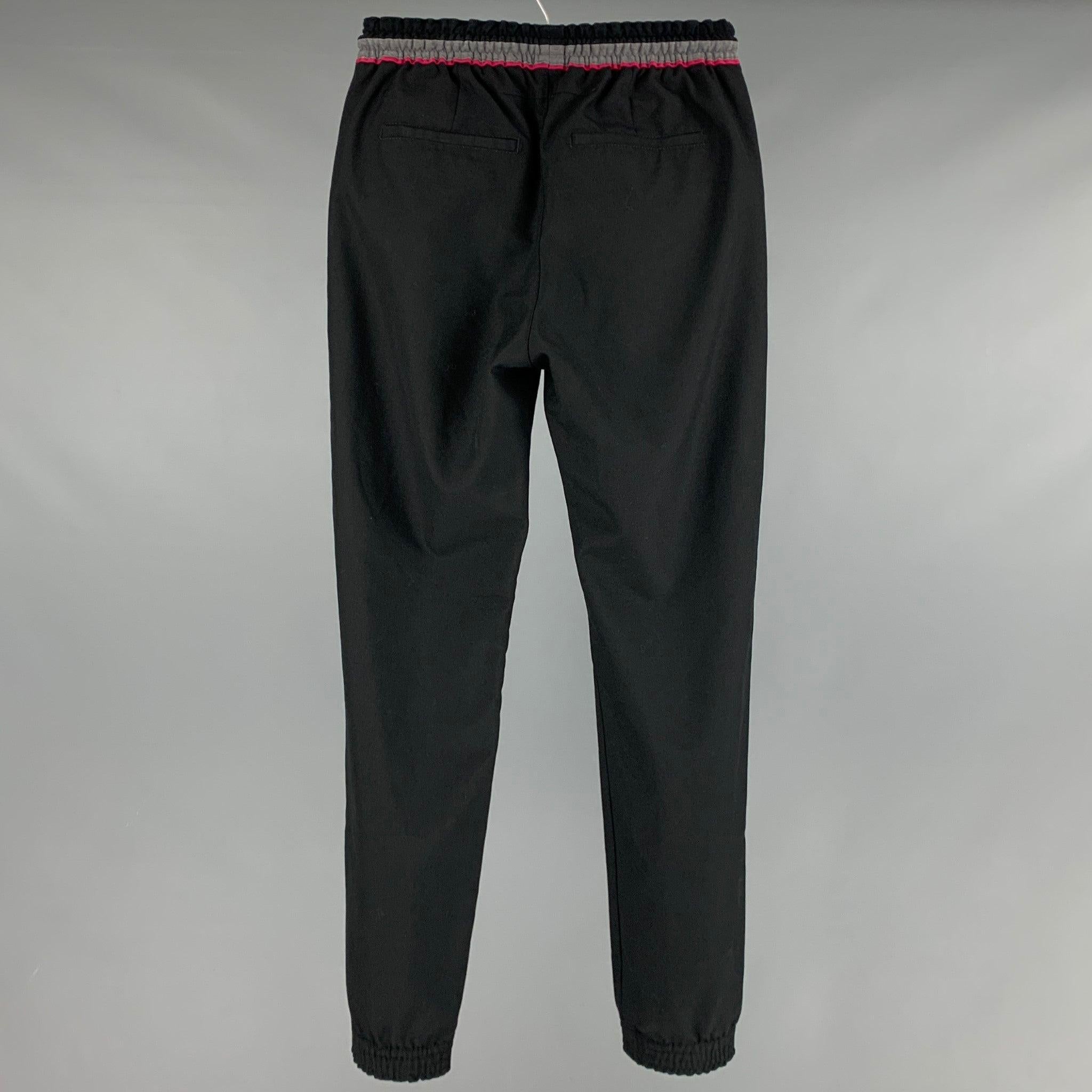 GIVENCHY sweatpants
in a black polyester wool blend fabric featuring zipper pockets, a drawstring waistband with grey and pink trim, and a zip fly closure. Made in Bulgaria.Very Good Pre-Owned Condition. Minor signs of wear. 

Marked:   44
