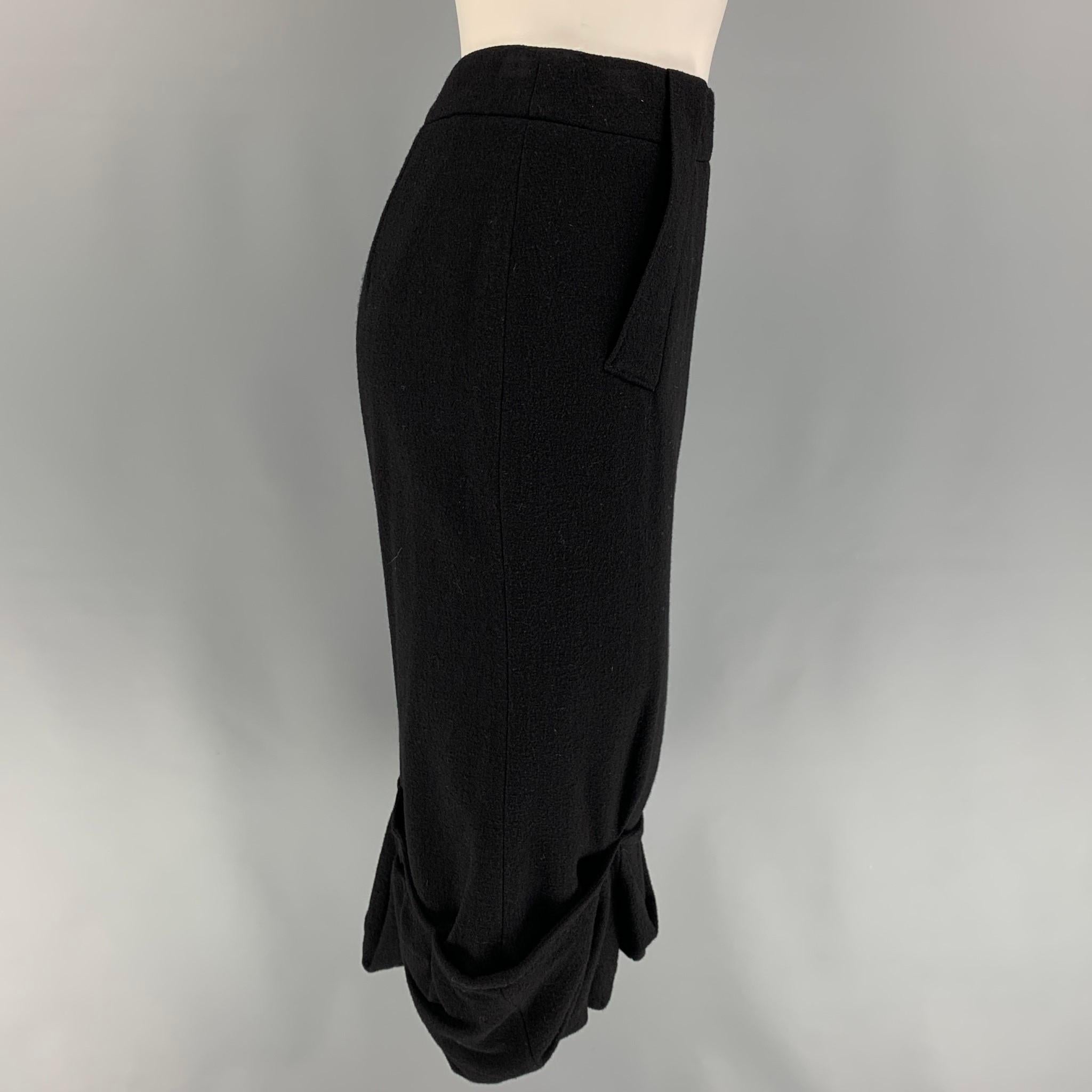 GIVENCHY skirt comes in a black wool featuring a ruffled hem, pencil style, and a back zip up closure. Made in Italy. 

Very Good Pre-Owned Condition.
Marked: 36

Measurements:

Waist: 27 in.
Hip: 32 in.
Length: 29 in. 