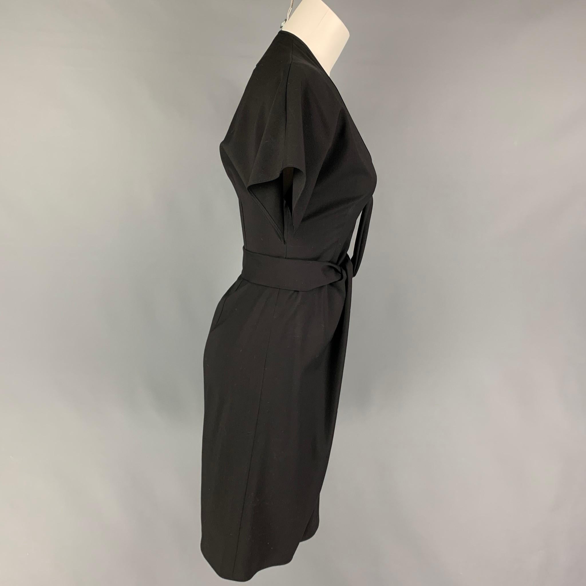 GIVENCHY dress comes in a black virgin wool featuring a v-neck, front ruched design, short sleeves, and a side zipper closure. Made in Italy. 

Very Good Pre-Owned Condition.
Marked: 38

Measurements:

Shoulder: 16 in.
Bust: 32 in.
Waist: 26