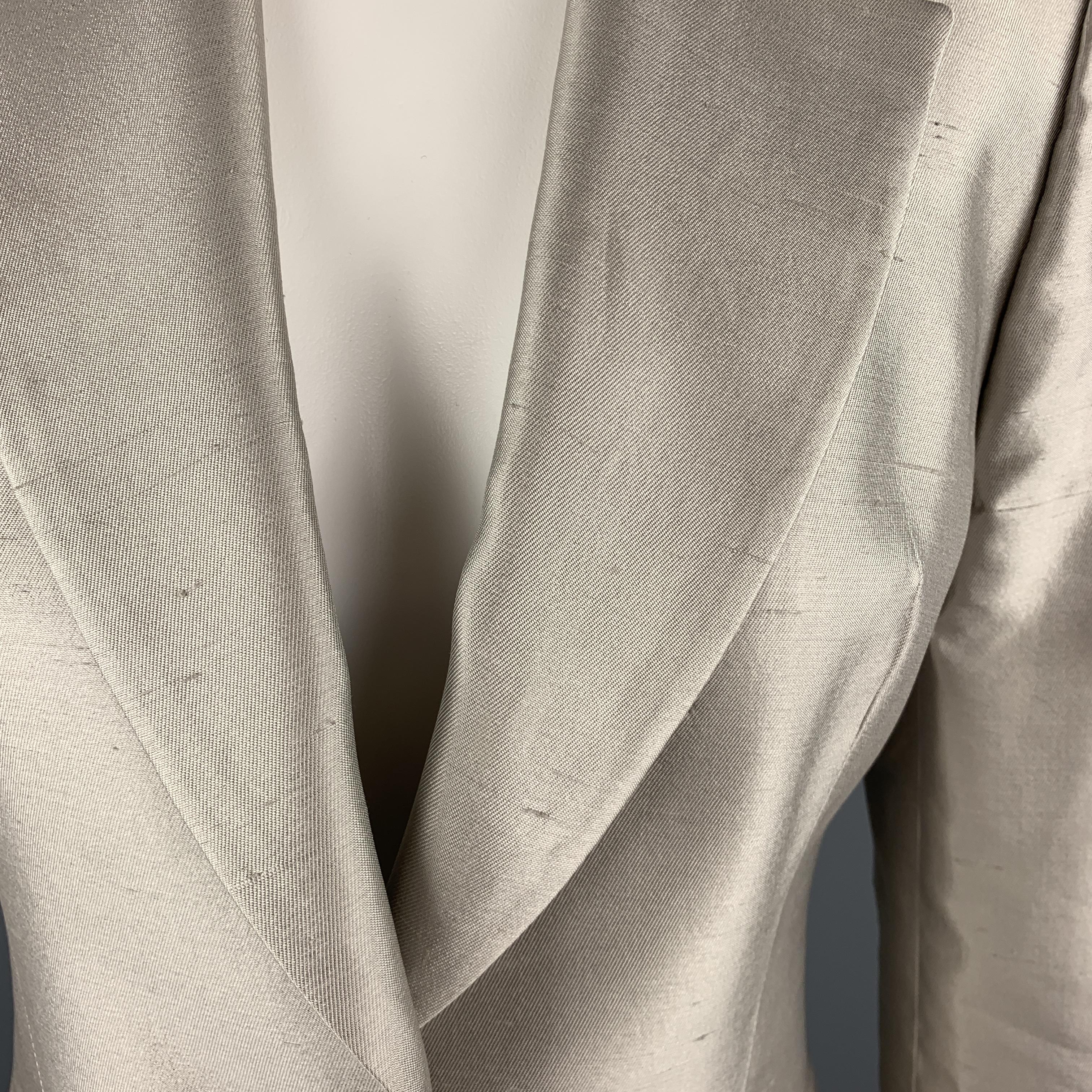 GIVENCHY blazer comes in muted silver silk shangtung with a notch lapel, single button front, cropped hem, and silver tone metal button detailed cuffs. Spot by button. As-is. Made in France.

Good Pre-Owned Condition.
Marked: FR
