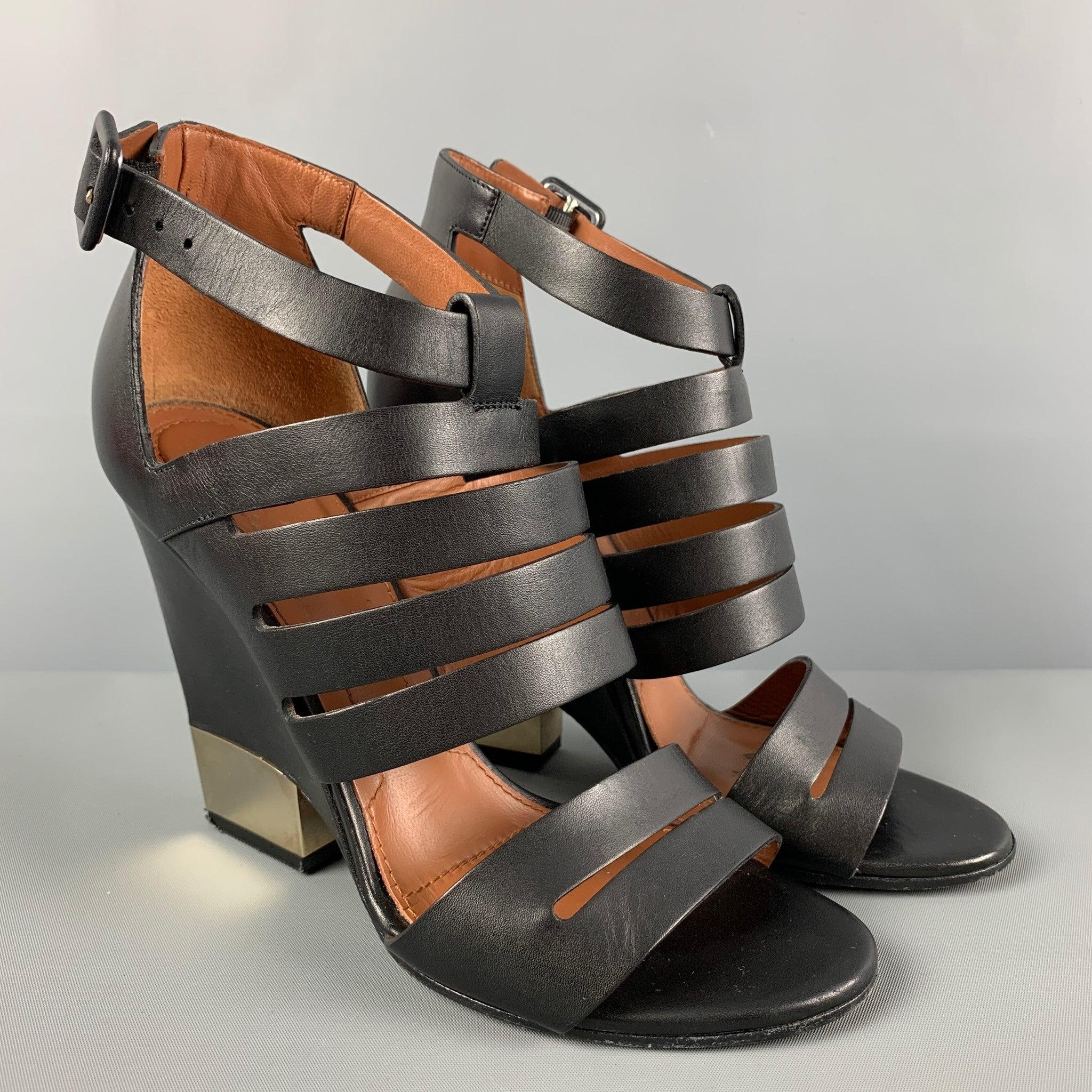 GIVENCHY heels comes in a black leather featuring a open toe, ankle strap closure, and a wedge heel with a metal detail.
Good Pre-Owned Condition.
Light wear. As-is.  

Marked:   36.5 

Measurements: 
  Heel:
4 inches 
  
  
 
Reference: