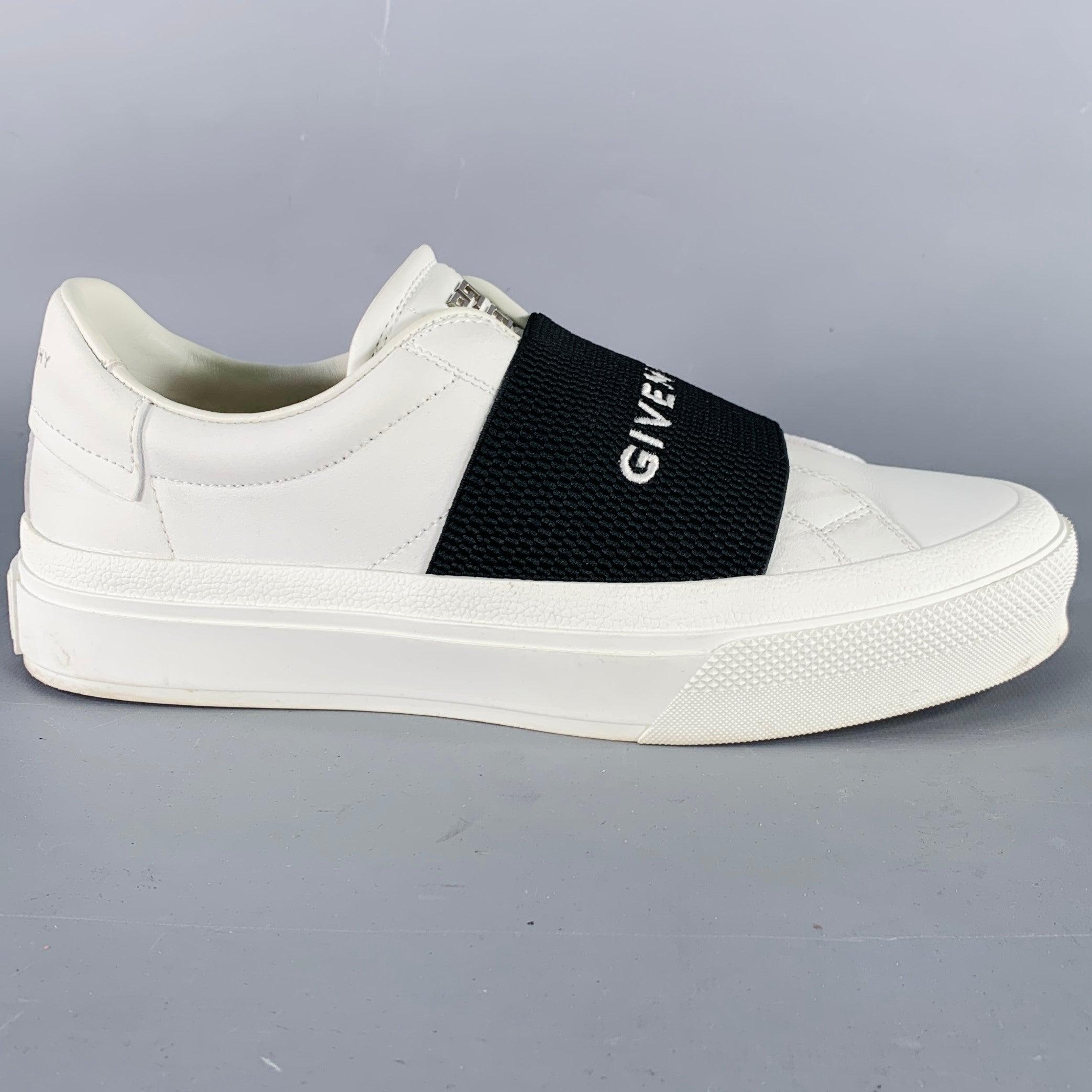 GIVENCHY sneakers in a white calfskin leather featuring black elastic logo, low top style, and slip on closure.Good Pre-Owned Condition. Moderate signs of wear on soles, light signs of wear on shoes. 

Marked:   38 DN 1211Outsole: 10.25 x 3.75