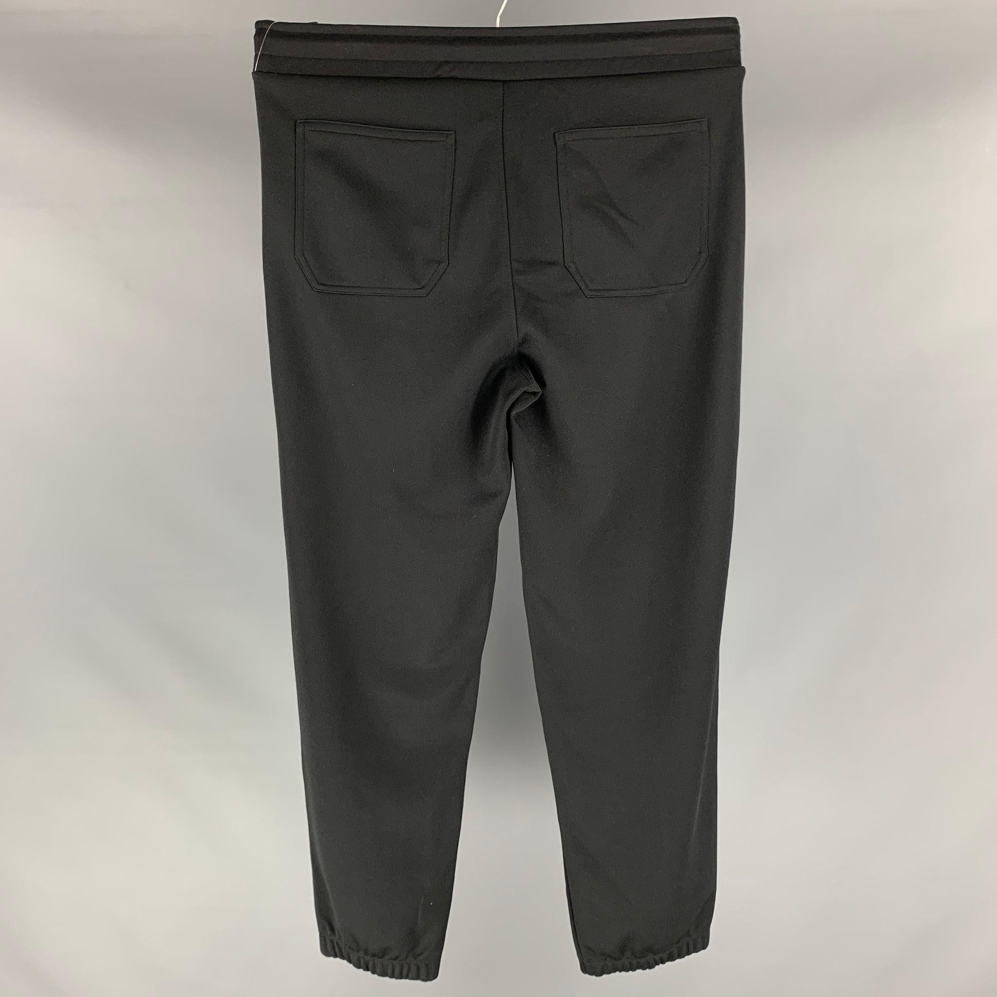 Le pantalon de survêtement GIVENCHY se compose d'une maille jersey en coton polyester noir, d'un logo, de poches zippées, d'une taille élastique et d'un cordon de serrage. Excellent état d'origine.  

Marqué :   L 

Mesures : 
  Taille : 33 pouces