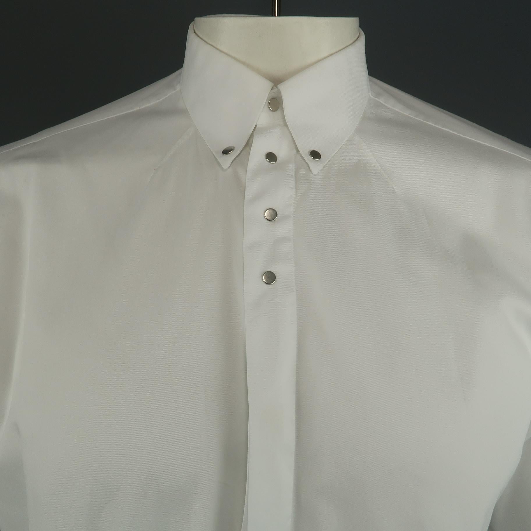 GIVENCHY long sleeve shirt comes in a white cotton featuring a button up style and silver snap details on the collar and upper closure.
 
Excellent Pre-Owned Condition.
Marked: 39
 
Measurements:
 
Shoulder: 17.5 in.
Chest: 48 in.
Sleeve: 25
