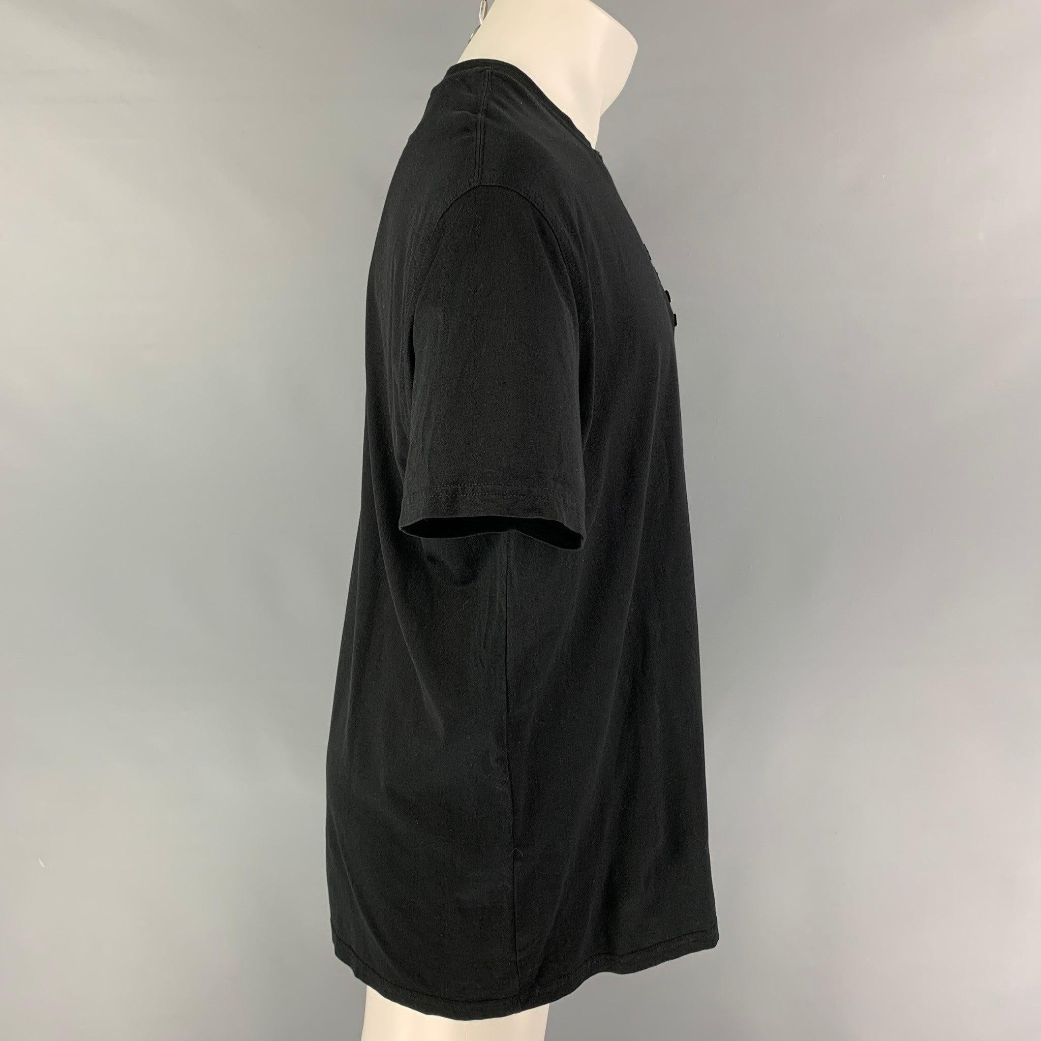 GIVENCHY t-shirt comes in a black cotton featuring front metal plaques, oversized fit, and a crew-neck. Made in Portugal.
Very Good
Pre-Owned Condition. 

Marked:   S 

Measurements: 
 
Shoulder: 21 inches  Chest: 46 inches  Sleeve: 9 inches 
