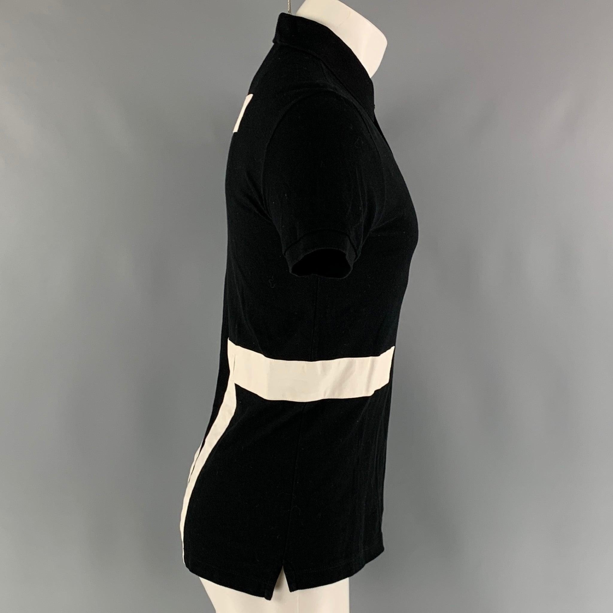 GIVENCHY polo comes in a black cotton piquet material featuring a spread collar, white wide stripes, and a half buttoned closure.Excellent Pre-Owned Condition.  

Marked:   XS 

Measurements: 
 
Shoulder: 17 inches Chest: 38 inches Sleeve: 8 inches
