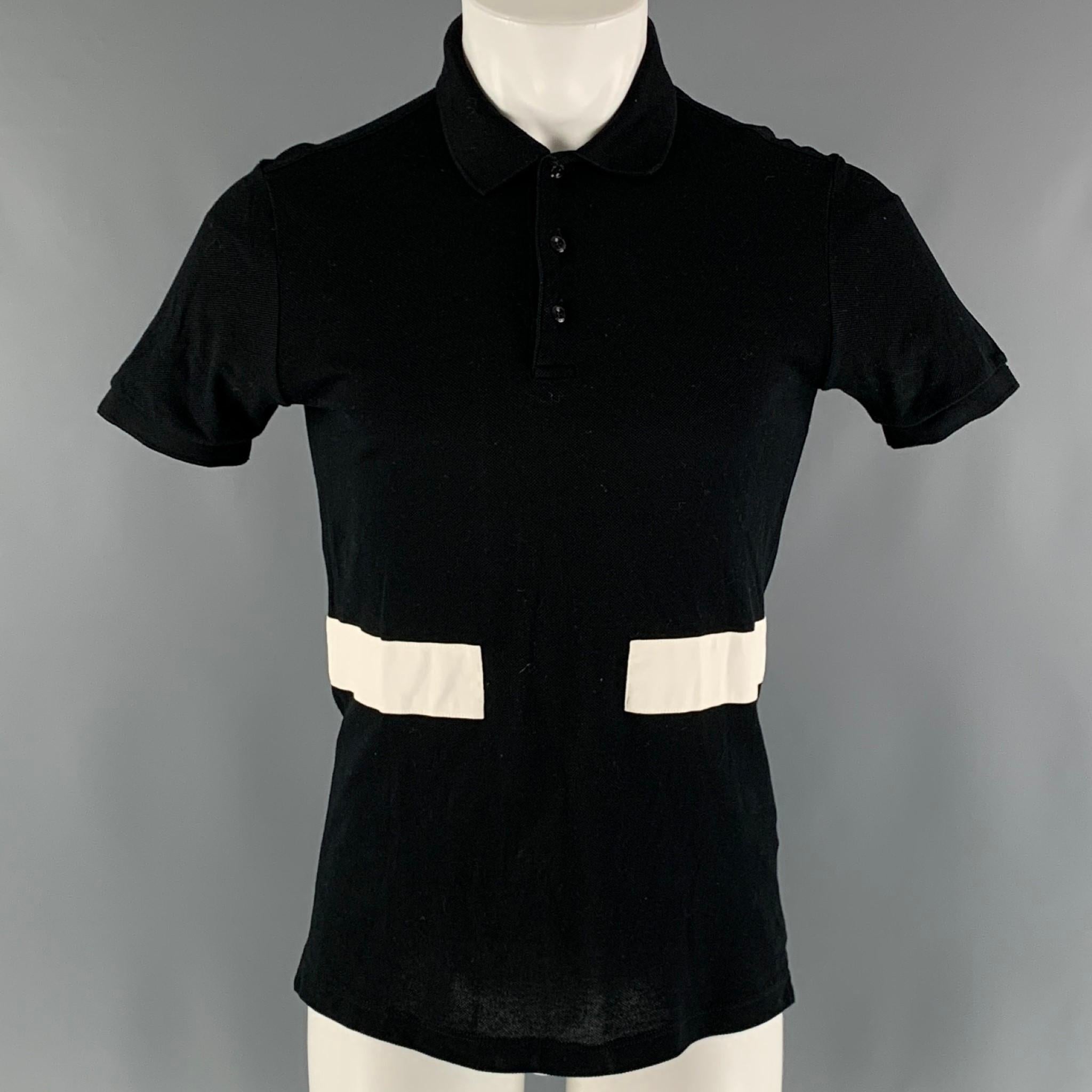 GIVENCHY polo comes in a black cotton piquet material featuring a spread collar, white wide stripes, and a half buttoned closure.

Excellent Pre-Owned Condition.
Marked: XS

Measurements:

Shoulder: 17 in.
Chest: 38 in.
Sleeve: 8 in.
Length: 28 in. 
